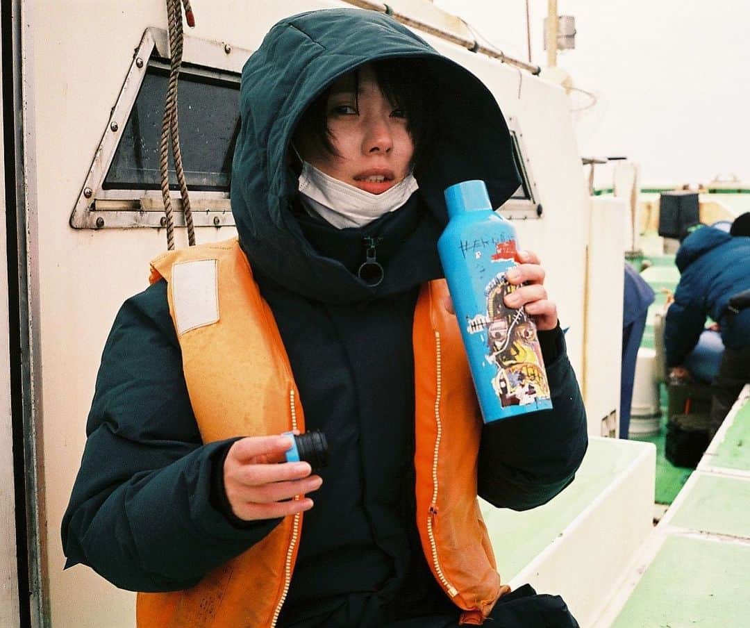 きなりのインスタグラム：「去年末初挑戦した海釣りの時の写真をもらった📸 @minori_nakada   甘鯛を釣りに🎣 冬だから寒そうだけど快晴予報だったから、大丈夫だよってみんなに言われてワクワクしながら早朝現場に着いたら、大雨☺️ 一向に止まず、海の風は強く、釣りのために買ったロシア製のダウンも浸水し、修行だった😇  でも、わたしの人生でアウトドアをしたことがほぼ無かったので、とても新鮮だった！(ここ2、3年はフジロックをアウトドアって言ってるくらいなのよ)  去年はコロナ禍でわたしの唯一のストレス発散である海外ひとり旅が出来ず、本当につまらなくて、自然の中に行ってみたいと沸々思っていて… それでみんなが連れ出してくれて、ちょっとずつアウトドアっぽいことを経験し始めてたんです。 自然は美しいし気持ち良いし暖かいし厳しい。 自分がとーってもちっぽけに思える。自然はどデカい！  海外旅行もいいけど、日本のことももっと見てみたい！ 生まれた国を今よりもっと好きになりたい。  楽しみは自分で作る。それに限る。  全身の感覚が無くなるくらい寒い海の上で飲んだみのちゃんお手製のミルクティー、沁みたなあ🫖  小さな幸せをコツコツ貯めてこう〜」