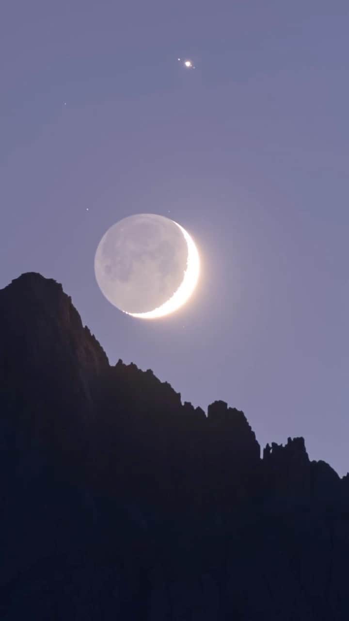 のインスタグラム：「A celestial conjunction pairs the crescent moon and Jupiter above the rugged profile of California's Mount Whitney in the Sierra Nevada in this time-lapse video by @babaktafreshi. Reaching an altitude of 14,505 feet (4,421 meters) it is the highest summit in the contiguous U.S. Note the Galilean moons of Jupiter are visible even with a telephoto lens. The dark side of the moon is gently lit by the Earth. That’s why it’s called earthshine (or the Da Vinci glow).」