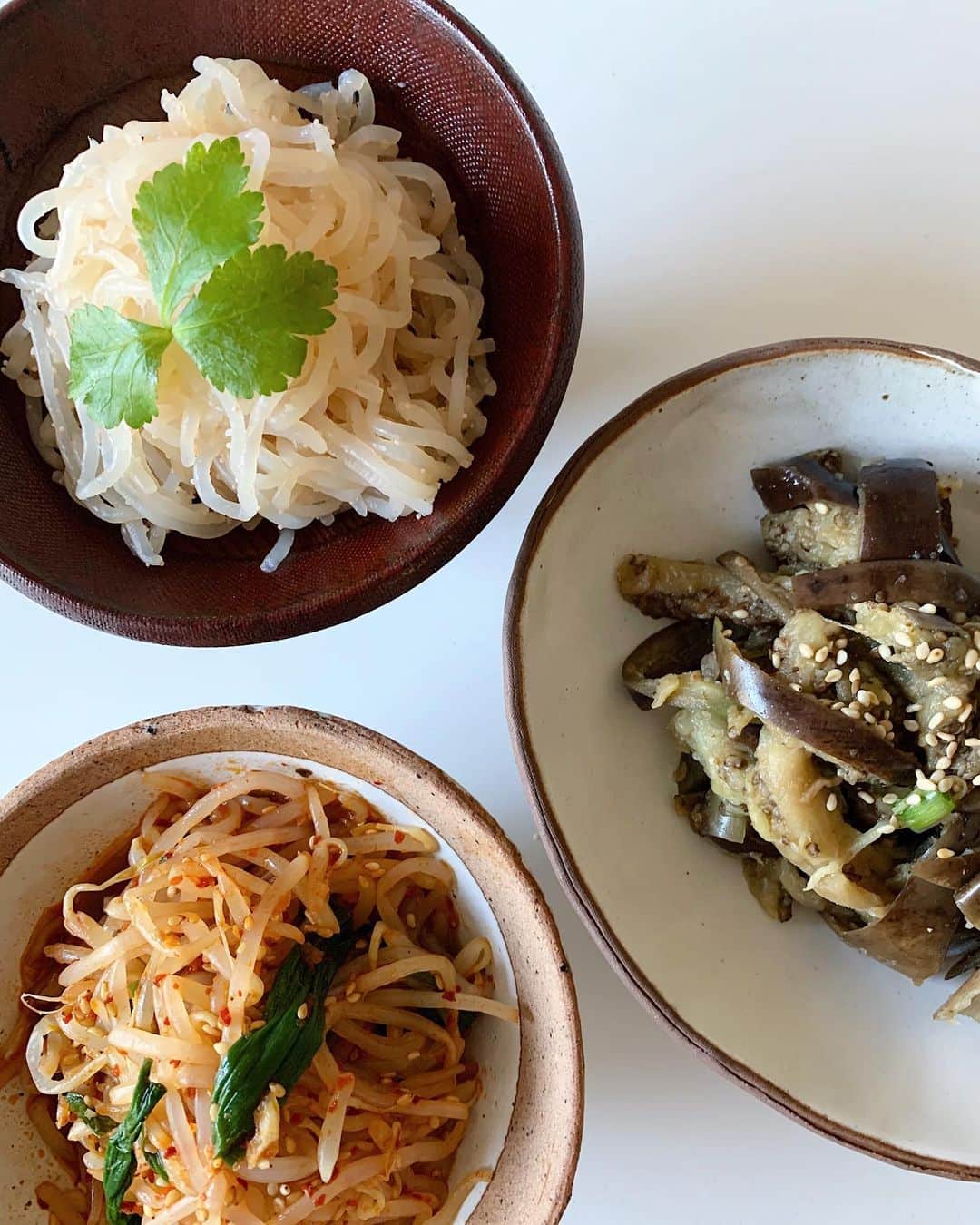 高木りなのインスタグラム：「今日の副菜🌿✨( recipeあり) - もやしのピリ辛ナムル - 茄子ナムル - たらことしらたき炒め  メインの鶏モモ肉の照り焼きは 食べる直前に焼く予定です♡  - もやしのピリ辛ナムル <ヤンニョム> 醤油、ごま油、唐辛子、炒りごま、ニンニクのみじん切り、今回は隠し味に食べるラー油をほんの少し入れてみました。  もやしとネギを耐熱容器でレンチン。 水気を切り、ヤンニョムと混ぜる。  - 茄子ナムル <ヤンニョム> 醤油、ごま油、エクチョ(魚醤)、塩、炒りごま、にんにくのみじん切り、太ネギの白い部分のみじん切り  茄子はラップに巻いてレンチンし、食べやすい大きさにカットし水気を切る。最後にヤンニョムとよく混ぜる。  - たらことしらたき炒め しらたきは食べやすい長さにカットし1分ほど茹でる。 ザルに上げ、フライパンで水気がなくなるまで乾煎り。酒、白だし、醤油少々、たらこを加えさらに炒める。  #오늘의반찬  매콤한 숙주나물, 가지나물, 시라타키와 타라코 볶음　 메인요리 탉다리살 테리야끼는 먹기 직전에 구울려고요✨ . . . #집밥 #반찬 #나물 #저녁메뉴 #리나스테이블 #도자기 #이도 #おうちごはん #晩ごはん #韓国料理 #ナムル #レシピ  #簡単レシピ #5分で副菜もう一品 #器 #器好き #rinastable #homecooking #namul #koreanfood #losangeles #calilife」
