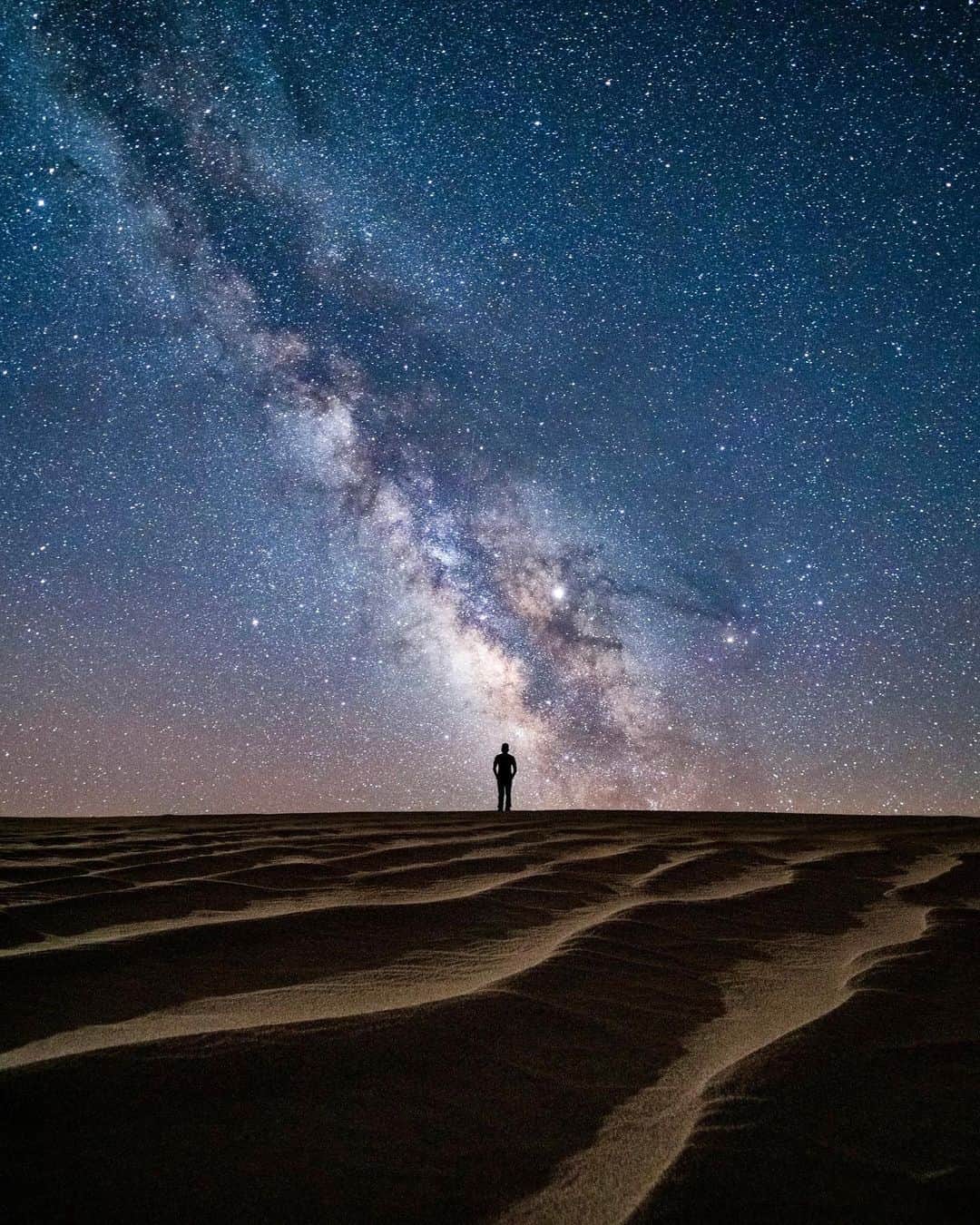 Travis Burkeのインスタグラム：「Solo night under the stars.  ⠀ This was one of those nights where I roamed through the sand dunes of Death Valley on foot for hours, constantly looking up at our galaxy and back down at the beautiful lines in the sand. A massive windstorm had swept through earlier that day, removing any trace of human presence. ⠀ Camera Settings-  ⠀ Focal Length: 14mm Shutter speed: 25 seconds Aperture: f/ 2.8 ISO: 8000 Lighting: I set up a very faint light off to the side to help illuminate the lines in the sand the way my eyes could see them from the glow of the stars.    I love pushing the limits of my gear, my imagination, and my body, all of which are usually more capable than I give credit 😂. Fun night exploring until the earth rotated back into view of our closest star!  ⠀ Check out my Stories right now to see a series of images where I share all of my camera settings and some tips! Let me know which ones were helpful to you. ⠀ #nightphotography #camerasettings #deathvalley #milkyway」