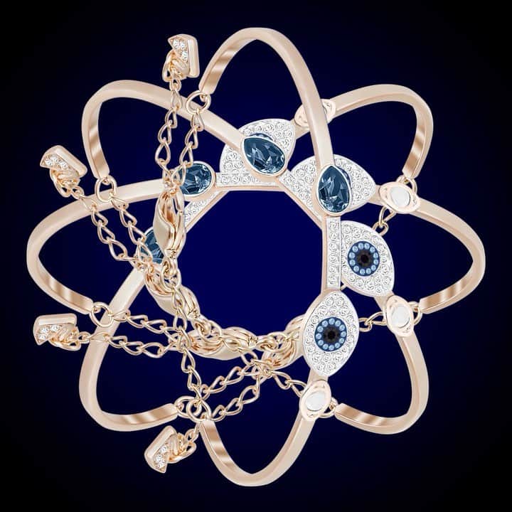 のインスタグラム：「All eyes on this bangle from our Swarovski Symbolic collection. Offering a striking contrast between rose gold-plated metal, crystal pavé, and blue crystals, it features two eye motifs and a blue crystal drop. #Swarovski」