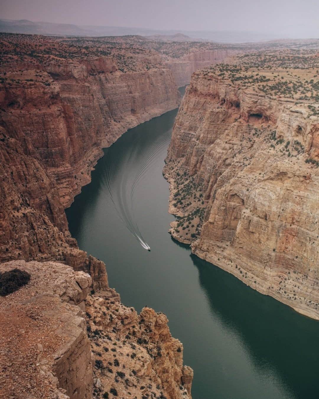 National Geographic Travelさんのインスタグラム写真 - (National Geographic TravelInstagram)「Photo by @joshuacogan / A speedboat moves through the lake at the Bighorn Canyon National Recreation Area on the Montana-Wyoming border. The lake is 71 miles (114 kilometers) long and was formed with the construction of the Yellowtail Dam, completed in 1967. Much of the park sits upon traditional Crow land belonging to the Crow people and contains remnants of villages and other cultural materials. The right rim of the canyon that you can see here is currently part of the existing Crow Reservation.  For more stories exploring Indigenous communities and the history of land rights, follow me @joshuacogan.」1月23日 8時36分 - natgeotravel