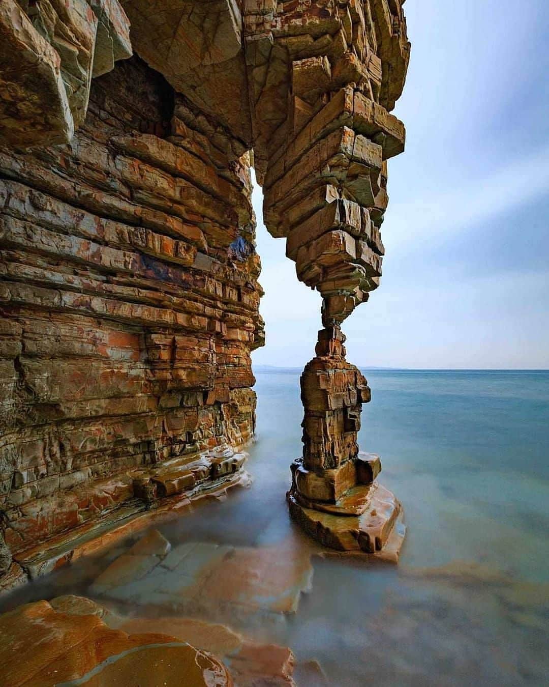 Discover Earthさんのインスタグラム写真 - (Discover EarthInstagram)「Would you like to go see this rock formation?  "In a small secluded rocky beach, approximately 120 Km from Dalian, there is this beautiful rock formation called "Table Leg Rock". There is a small "catch" to go there: you have to walk along the beach beside a steep cliff at low tide to reach this place. When we went there it was around 3,30 p.m. Then you have to wait until the tide rises up to the feet of the rock to get a nice foreground of the stones covered by the sea, and this happened around 6 p.m. The problem was that by 7 p.m. the way back was completely submerged, the tide kept rising constantly until 10 p.m., flooding completely the small beach we were standing on and pushing us to find shelter in a small narrow cave behind the rock, where we had to wait until 3.30 in the morning for the tide to retreat and make the passage along the beach manageable again !!! So if you go there, be prepared to spend half a day buried in a cave like a bear....."  #discoverchina🇨🇳 on #pinterest with Raimondo Restelli   . . . . .  #china  #beijing  #中国  #shanghai  #rockformation  #nature  #travel  #landscape  #travelphotography  #rocks  #photography  #naturephotography  #hiking  #landscapephotography  #adventure  #rock  #beach  #explore  #travelgram  #roadtrip  #wanderlust  #geology  #vacation  #beautifuldestinations  #naturelover」1月25日 0時30分 - discoverearth