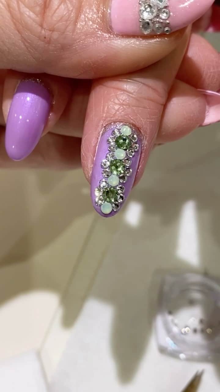 名古屋プレミアムネイルサロン アデリーネイルのインスタグラム：「パープルとグリーンの春らしい組み合わせ🌿  オリジナルストーンデザインが美しい  flowerをイメージしたビジューの連なりが綺麗  アデリーにて是非  アデリーネイル ☎︎052-325-2533 名古屋市北区若葉通1-2レクサ若葉2階 1階無料駐車場となっております(6台有)#アデリーネイル#プレミアムネイルサロン #ネイル#ネイルサロン#名古屋#名古屋ネイルサロン#3Dネイルアート#nails#gelnails#nailart#スワロフスキークリスタル#アイラッシュサロン#サロンデザイン#フレンチネイル#ドット#flowernails #네일#무광네일#살롱#flower#スワロフスキーが好き#スワロフスキーネイル#ビジューアート」