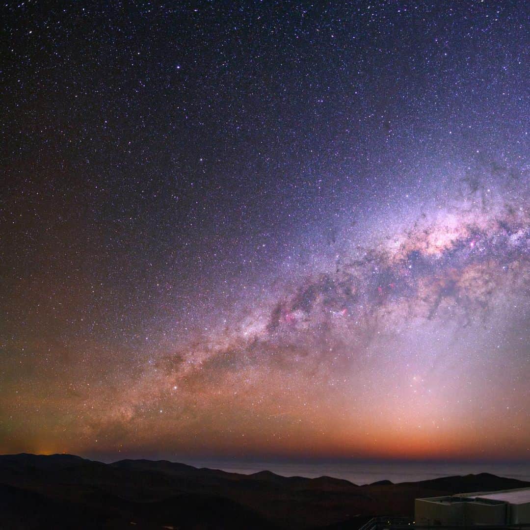 のインスタグラム：「Photo by @babaktafreshi / Slowly swipe to see the entire view of how we explore the far universe. The Milky Way gleams in all its splendor, as seen from a mountaintop in Chile. Cerro Paranal is home to the Very Large Telescope (VLT), a complex of four  scopes in the Atacama Desert. Here, one of them emits a laser for an adaptive optics system that removes the blurring effect caused by air turbulence. Below the bright core of the galaxy is the zodiacal light—sunlight scattered by asteroid dust, appearing through the fading dusk and above the cloud-covered shores of the Pacific Ocean. A satellite flare (sudden reflection of sunlight) appears on the horizon, resembling a meteor. Explore more of night sky wonders with me @babaktafreshi. #twanight #nightsky #exploration #atacama @esoastronomy」