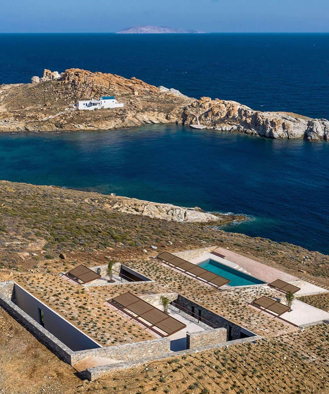 The Cool Hunterさんのインスタグラム写真 - (The Cool HunterInstagram)「Designed by Athens-based @moldarchitects nCAVED is currently high on our list of genuinely original yet refreshingly unpretentious vacation residences. The drama of the severe rocky landscape is repeated with dramatic skill in the chiselled strictness of the building.  Completed in 2020, nCAVED’s 340 square metres (3,660 sq.ft) of space disappear into the rock in a protected cove on the island of Serifos. From the outside it brings to mind the entrance of a pyramid or tomb. Yet from the inside, the living rooms are filled with natural light and afford spectacular views of the Aegean Sea. The strong northerly winds of the sea were one of the key considerations in the planning process that resulted in a dramatic solution providing both extreme shelter and stunning views. (Link in profile) #swipeleft」1月26日 14時37分 - thecoolhunter_