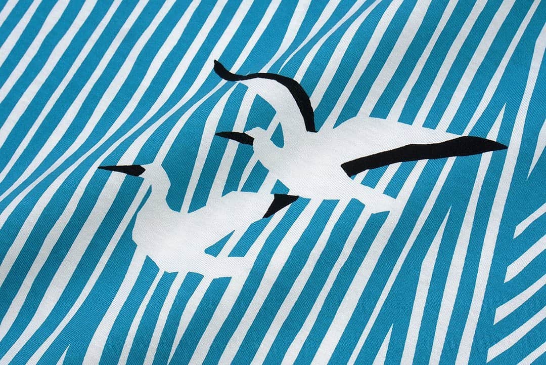 marbleSUD(マーブルシュッド) のインスタグラム：「「2021 spring & summer」 コウノトリ  ヨーロッパでは、赤ちゃんを運んできてくれる鳥として愛されているコウノトリ。背景に描いた動きのあるストライプは、大空を漂う風にも、大海原のさざ波にも見えてきます。見つめていると、時間がゆったりと穏やかに流れていくような、不思議な感覚を覚えます。  全部で5型展開の「コウノトリ」シリーズ。カジュアルに楽しめるカットソー生地と、上品な印象の布帛生地。印象の異なる2種類の生地で表現しました。  本日はカットソー生地の3型が入荷しました。」