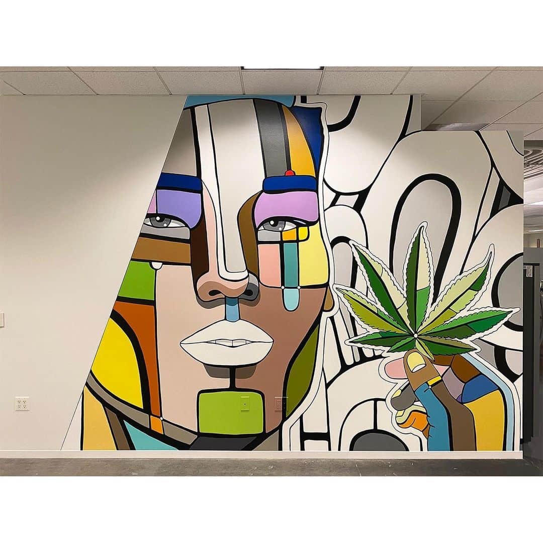 デヴィッド・ギルモアのインスタグラム：「This is a continuation of what I posted yesterday about my mural project for Weedmaps Irvine, CA offices.  Those offices were being redesigned and renovated by @lpainc while I was painting and in some of the photos you can see the changes happening. Lemme explain... the first photo shows an angled starting point of the mural with the artwork then wrapping around to another long wall with a pop out appliance nook. That nook eventually will have two refrigerators and a coffee station. As the artwork travels over and through that nook it goes at a long angle down the connecting wall which after I painted had some shelves installed. Makes sense? There’s a short video to help explain.  The space was still being worked on after I finished so I’ll have more photos once the space reopens. Thanks Weedmaps and LPA Inc! #weedmaps #lpa #lpainc #architecture #design #mural #designmural #officemural #popart #weedartwork」