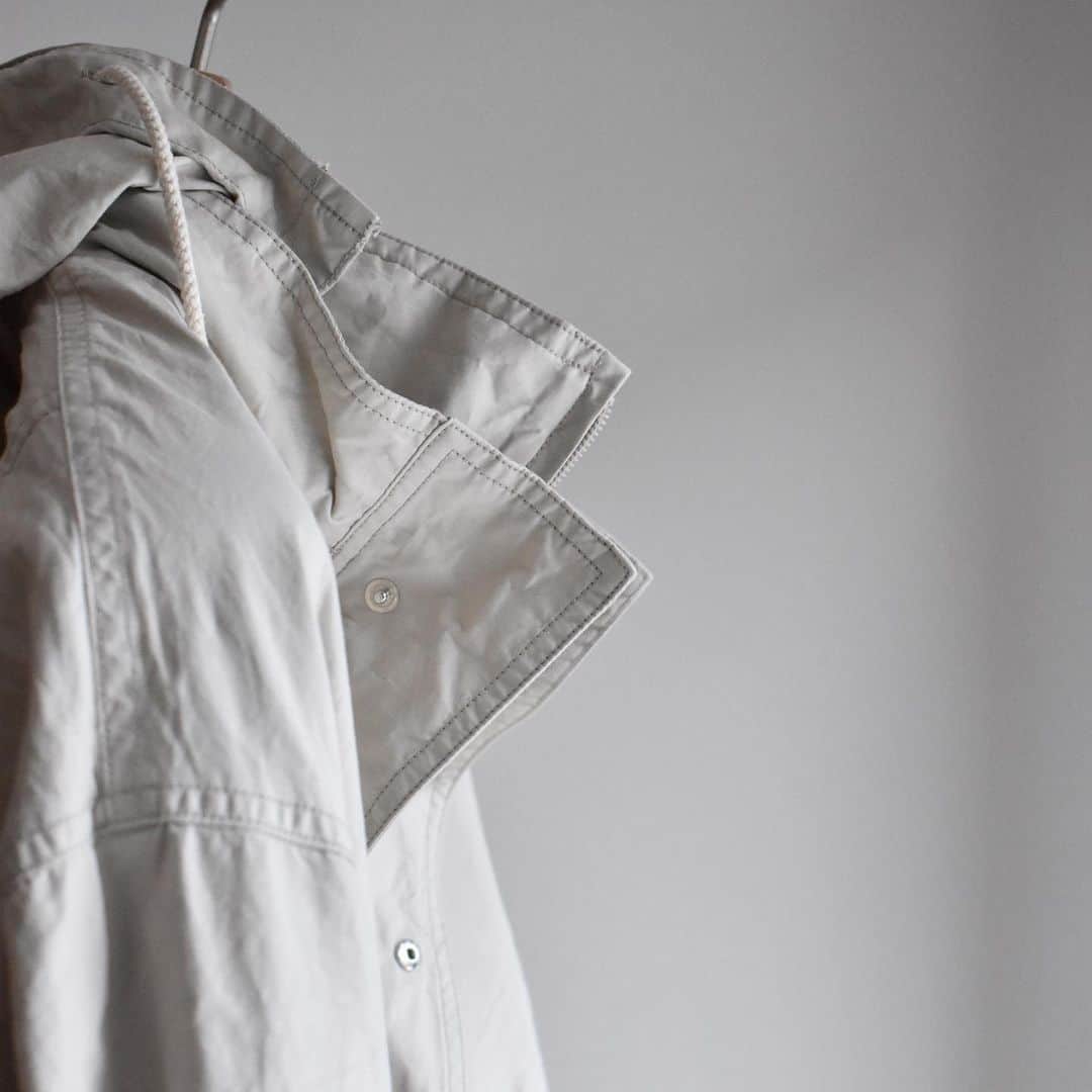 キャプテン サンシャインのインスタグラム：「﻿ "Portage Blouson"﻿ ﻿ Light Beige / Navy﻿ ﻿ 先染のエジプト超長綿を限界まで打ち込み、仕上げた高密度オックスフォード素材。﻿ 着脱フードや袖のジップポケット﻿ などミリタリー要素を取り入れながら、コットン素材を無双仕立てにすることで、独特な丸みと柔らかい表情に仕上げました。﻿ 製品洗い、撥水加工を施しています。﻿ ﻿ #kaptainsunshine ﻿ #21ss」