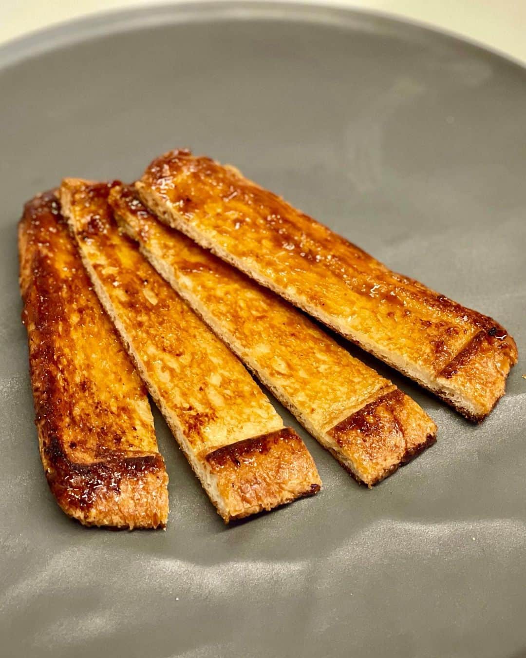 のインスタグラム：「昨日、Clubhouseでこれの話になって久しぶりに食べたくなったので、クイニーアマン風バターたっぷりシュガートースト♡﻿ ﻿ たっぷりバターで食パンをフライパンで押しつぶしながら表裏焼いて砂糖を大さじ１かけてから表裏押しつぶしながら焼くだけでめちゃ旨♡﻿ ﻿ #グギメシ #具義スイーツ2021 #具義パン2021 #モジャメガネ焼き菓子部」