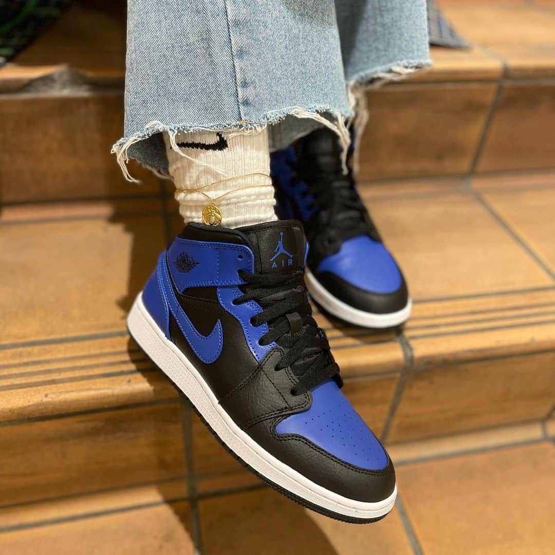のインスタグラム：「. NIKE AIR JORDAN 1 MIDから新色が登場！ 絶大な人気を誇るオリジナルカラーの"ROYAL(ロイヤル)"をオマージュしたカラーリング🔥漆黒のボディはシュリンクレザーで構成、そこにハイパーロイヤルのスムースレザーをアクセントに取り入れて全体を引き締め高級感あるデザイン。オリジナルとは異なり、アイステイをブルーで染め上げることで、普段使いしやすい軽やかな一足になっています✨2/5(FRI)より発売開始。ぜひお見逃しなく🔥  #atmos#atmospink#アトモス#アトモスピンク#スニーカー#スニーカー女子#NIKE#ナイキ」