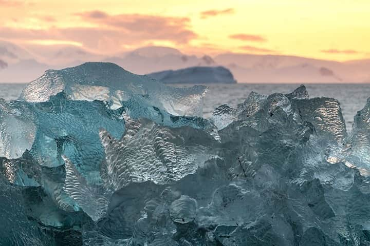 National Geographic Travelさんのインスタグラム写真 - (National Geographic TravelInstagram)「Photo by @daisygilardini / While cruising on a sailboat along Antarctica, we crossed this mesmerizing blue iceberg. Icebergs form when ice calves from glaciers. Snow accumulates on top of a glacier and is compressed over time by new precipitation. The surface snow contains a lot of air, which reflects visible light—light we perceive as being white in color. After thousands of years of compression, the tiny air bubbles in the snow become squeezed. When the light hits the compressed ice, instead of bouncing back, it's partially absorbed. The ice absorbs longer color wavelengths, such as red and yellow, reflecting the blue and green visible to our eyes.  Follow me @daisygilardini for more images and behind-the-scenes stories. #Antarctica #iceberg #climatechange #climatechangeisreal #polar」2月1日 8時35分 - natgeotravel