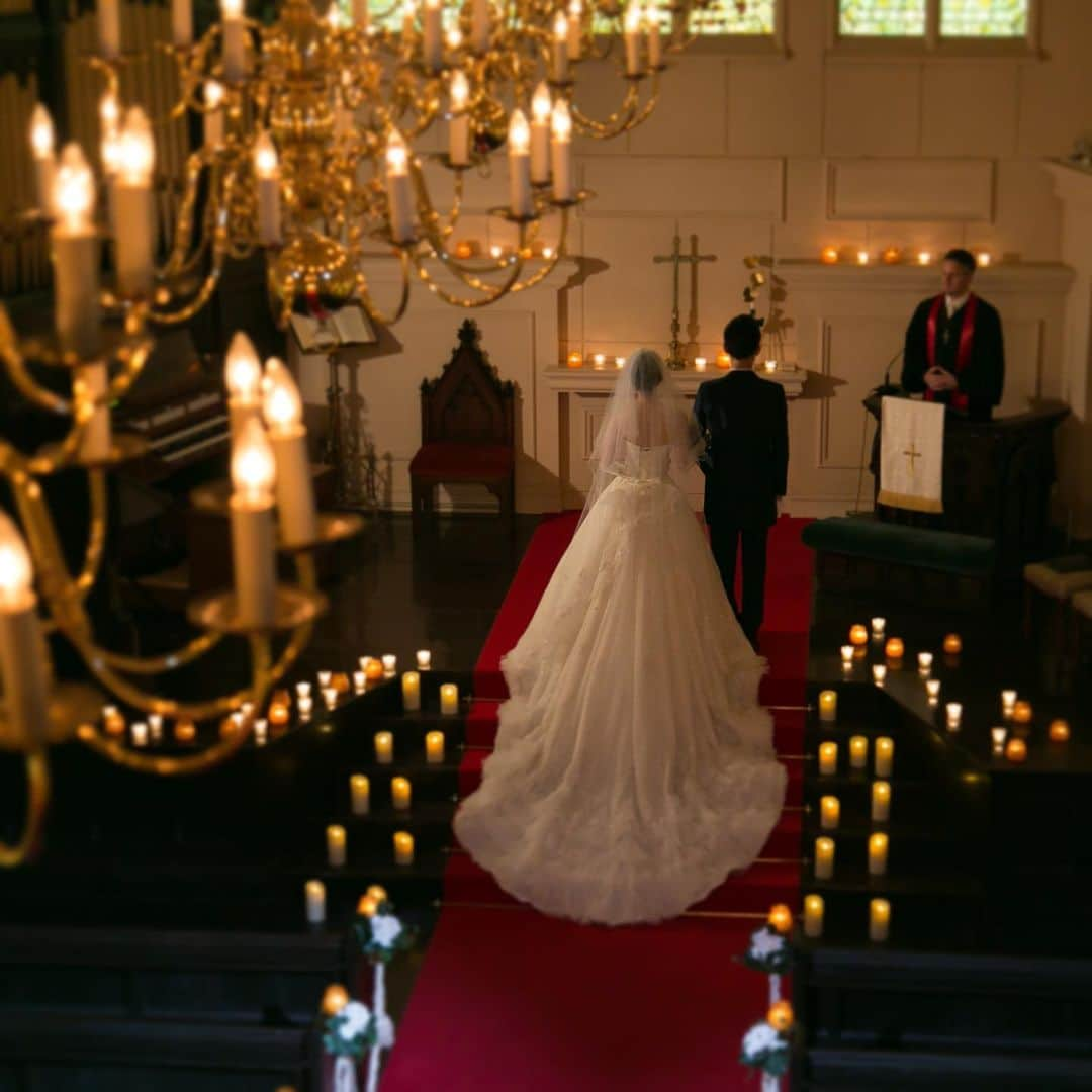 ロイヤルホールヨコハマ【公式サイト】のインスタグラム：「🕯Candle Wedding🕯  クラシカルな大聖堂の中 灯りに包まれ 炎揺らめく幻想的なお式を キャンドルが演出🕯✨  白ドレスと大聖堂、 キャンドルライトとの コントラストが素敵です🎞✨  .｡.:*・ﾟ＋.｡.:*・ﾟ＋.｡.:*・ﾟ＋.｡.:*・ﾟ＋.｡.:*・ﾟ＋.｡.:*・ﾟ＋ 横浜の街 結婚式場  ロイヤルホールヨコハマ公式Instagramです🎞  是非、ハッシュタグ #ロイヤルホールヨコハマ を付けて投稿して下さい☘️  素敵なお写真は 公式アカウントでご紹介させて頂くことも？！  💐ロイヤルホールヨコハマでお式を挙げた卒花嫁様の実例写真を中心に更新中です✨」