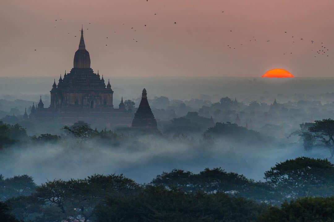 Michael Yamashitaさんのインスタグラム写真 - (Michael YamashitaInstagram)「A troubling new dawn in Myanmar: Bagan is an ancient city and a UNESCO World Heritage Site, and since 2011, one of Myanmar's most popular tourist and pilgrimage sites. From the 9th to 13th centuries, the city was the capital of the Pagan Kingdom that unified the regions that would later constitute Myanmar. During the kingdom's height between the 11th and 13th centuries, more than 10,000 Buddhist temples and pagodas were constructed in the Bagan plains alone, of which the remains of over 2200 temples and pagodas survive. "Temples of gold” is how Marco Polo described them in his Travels of Marco Polo -- “… and when they are lighted up by the sun they shine most brilliantly and are visible from a vast distance.” The age and majesty of these gold-plated temples are reminders that despite current troubling political upheavals, Myanmar is an ancient land that has prevailed throughout ever-shifting alliances and wars for hundreds of years. #bagan #myanmar #bagansunrise #worldheritage @thesilkroadjourney」2月1日 23時32分 - yamashitaphoto