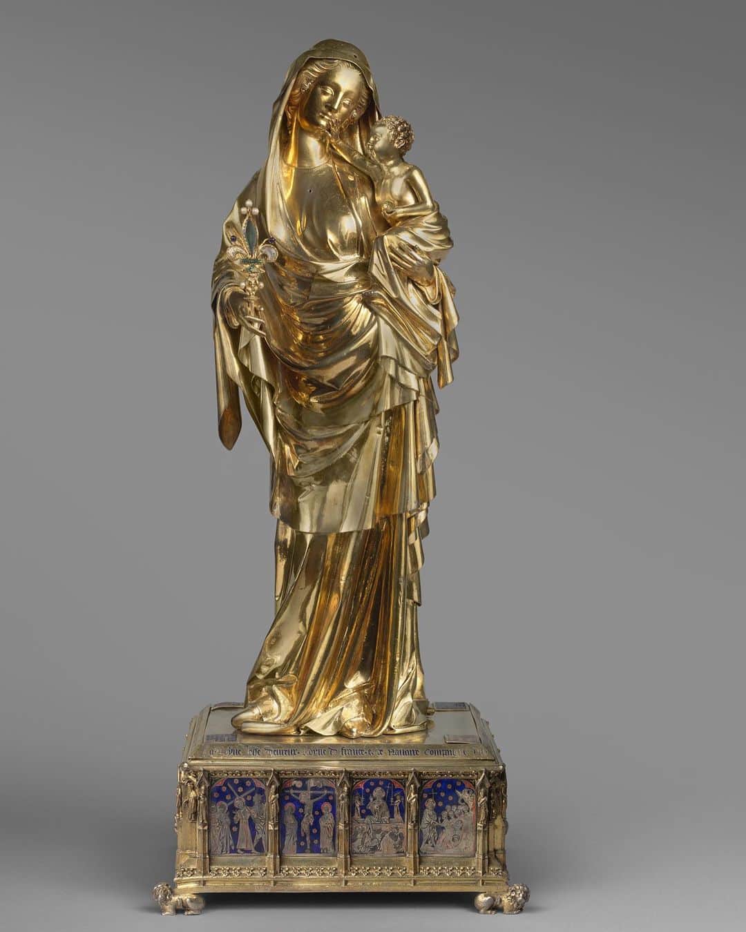 ルーブル美術館さんのインスタグラム写真 - (ルーブル美術館Instagram)「. 🇫🇷 Nous vous souhaitons une #BonneSemaine avec cette Vierge à l’Enfant ! ☺️ - ✍️ Cette statuette haute de 68 centimètres fut donnée par la reine Jeanne d’Evreux à l'abbaye de Saint-Denis en 1339, comme l’indique l'inscription du socle. - ⚜️ La Vierge tient à la main une fleur de lys d'orfèvrerie et de cristal dans laquelle étaient enfermés des reliques des vêtements, des cheveux et du lait de la Vierge. De nombreux matériaux composent cet objet d’art : Argent doré, émaux de basse-taille sur argent doré, pierres et perles. - 🦁 Le socle qui soutient la Vierge est supporté par quatre petits lions. Très architecturé, il est rythmé par de petits contreforts délimitant des niches dans lesquelles se trouvent de petites statuettes de prophètes. Entre les contreforts, quatorze plaques d'émaux translucides sur basse taille retracent les épisodes de l'Enfance et de la Passion du Christ. - - - - 🌍 We wish you a #GoodWeek with this Virgin and Child! ☺️ - ✍️ This 68 centimeters high statuette was given in 1339 by the Queen Jeanne d’Evreux to the Abbey of Saint-Denis. The inscription on the pedestal shows that the gift was presented to the abbey in 1339. - ⚜️ In her hand, the Virgin holds a fleur de lys of gilded silver and crystal. The lily contained relics such as scraps of clothes, hair, and milk of the Virgin. Many materials form this piece of art: Gilded silver, basse-taille enamels on gilded silver, stones and pearls. - 🦁 The statue's pedestal rests on four tiny lions. The architectural base is structured by miniature buttresses framing niches that house small statuettes of the prophets. Between the buttresses are fourteen plaques of translucent basse taille enamel depicting scenes from the childhood and Passion of Christ. - 📷 © Musée du Louvre, dist. RMN - Grand Palais / Hervé Lewandowski /Martine Beck-Coppola . . . #Louvre #MuséeDuLouvre #LouvreChezVous #MuseumFromHome」2月2日 1時20分 - museelouvre