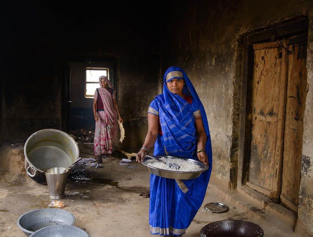thephotosocietyさんのインスタグラム写真 - (thephotosocietyInstagram)「Photo by @smitashrm // Bimla and Sarita work as cooks at a government run school in Uttar Pradesh, India. I met them in 2015 while working on a personal project. Both Sarita and Bimla never had the opportunity to earn before this job as both had been married in their teens after dropping out of school because of poverty.  The Indian government introduced mid day meal programme in government and government-aided schools to increase school enrolment and attendance. Another big reason was to address malnutrition. In rural India, most people are so poor that sending their children to school is not an option even if they don't have to pay a tuition fee. But a free freshly-cooked wholesome lunch for their children is a strong reason to send their children to school.  With this pandemic, the closure of govt schools has disrupted the mid-day meal scheme which covers millions of children and malnutrition has risen among the most vulnerable communities.   Follow me @smitashrm for more images and stories about human rights and social issues from across the globe. @thephotosociety @natgeo #education #pandemic #covid19 #malnutrition」2月2日 3時31分 - thephotosociety