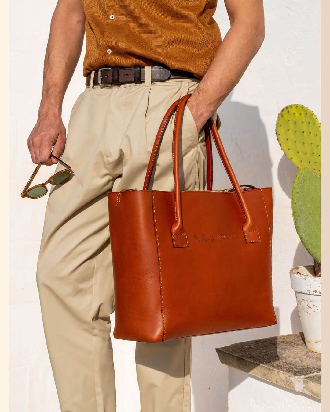 Felisi Japan 〔フェリージ〕のインスタグラム：「【2021 SPRING & SUMMER COLLECTION】 . ■SUSTAINABILITY LINE –PUNTO A MANO- . 創業当時のフェリージは、全行程を手縫いで行い、 ノンケミカルで製造されたレザーを使用していました。 「Punto a mano」はそんなフェリージの原点に立ち返って、 次の未来を見つめるモデルと言えます。 フェリージを象徴するバケッタレザーをサステナブルな方法でつくり、 そのレザーで一生モノのバッグをつくる。 洒脱で、軽快で、でも揺るがないフェリージの信念を、 このバッグから感じ取ってください。 . Model No. 21/26/A Price : ¥110,000 . ▶詳しくはプロフィールページからもご覧いただけます。 . . . #felisi #felisiselection #felisicollection #SS21 #newcollection #sustainability #puntoamano #leatherbag #vachettaleather #totebag #bag #フェリージ #フェリージセレクション #フェリージコレクション #2021年春夏 #新作コレクション #サスティナビリティ #プントアマーノ #バケッタレザー #レザーバッグ #レザートート #トートバッグ #バッグ #かばん #鞄」