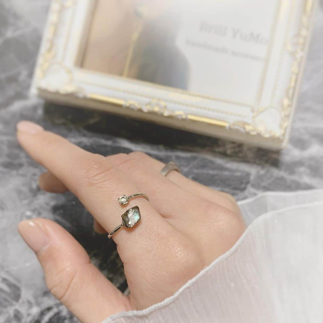 板野優花のインスタグラム：「💍Brill YuMo ハンドメイドリング @brillyumo ・ お気づきの方もいるかもですが ここ最近、リングにハマっていて お気に入りを見つけてはお迎えしてます☺️💓 普段の服装が派手な方ではないから リングもシンプルなデザインが好き🥰 ・ 今回お迎えしたのはパウアシェルに 銀箔があしらわれているのが印象的なハンドメイドリング✨ 小さい方の石はチェコガラスだって☺️💓 ・ リング大好きなんだけど これ！と思ったやつがサイズ合わないとか よくあって悔しい思いをするんだけど 今回のリングは芯が真鍮製らしく 5～20号くらいまでサイズチェンジできるそう！✨ フリーサイズ本当にありがたい🙏💕 ・ モチーフ同士の間隔をあけたり、サイズが変えられるから ファランジリングにもできたり 日によってつける場所を変えられるのも嬉しい🥳💓 ・ #brillyumo #ブリルユーモ #フォークリング #ハンドメイドリング #おすすめアクセサリー #天然石アクセサリー #手作り指輪 #ファランジリング #フリーサイズリング #真鍮リング #シェルリング #ガラスストーン #おしゃれさんと繋がりたい #ゆーろの可愛いメモ  #シルバーアクセサリー #ユニセックスアクセサリー #リング  #アクセサリー好き  #手フェチ #置き画 #置き画くら部 #pr」
