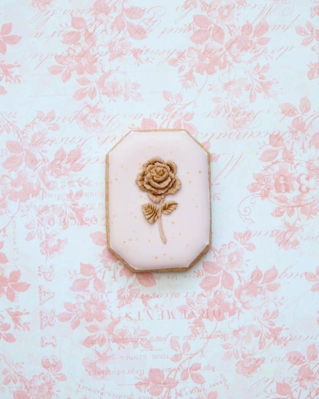 KUNIKAのインスタグラム：「Milk chocolate colored petit icing sugar rose cookie.🥀  ミルクチョコレートをイメージした薔薇のしぼり🥀  ❃ LINER 10/0 の細筆を使って溝に色をつけ印影を出し、さらに立体感を出しました。  ❃ 背景は FLAT 2 を使って、ゴールドでしぶきを散らしました。  お気に入りです♡  オンラインショップオープン期間中に、あと一回インスタライブすることに決めました🌼 3月1日21:00〜、です。 タイミング合う方はぜひ❃  え、もう3月....???  #artofkunika」