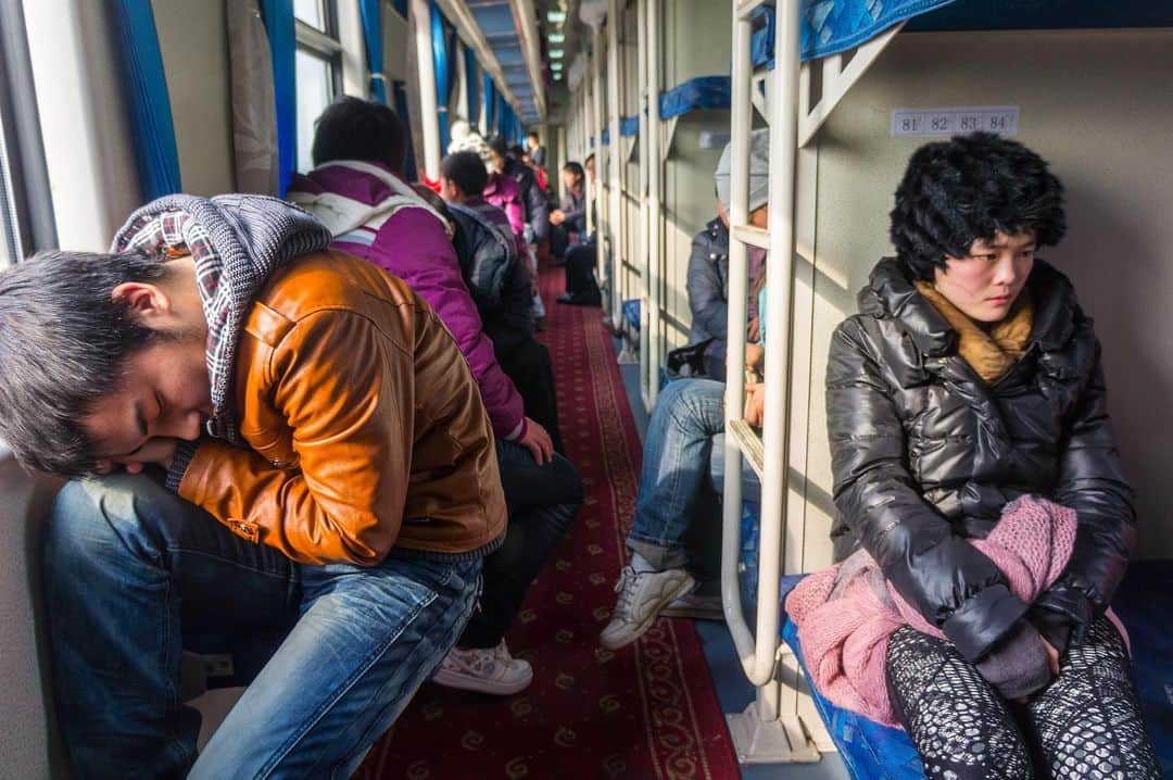 Michael Yamashitaのインスタグラム：「Party’s over: Heading for home at the end of the China’s Lunar New Year holiday. In pre-pandemic years, the Spring Festival period saw some 300 million migrant workers and students heading for their home towns in what was the largest annual human migration in the world, jamming roads and rails for 40 days, before, during, and after the the festivities surrounding the celebration welcoming the Lunar New Year.  This year, amid fears of a resurgence of Covid 19, the China’s National Health Commission put strict rules in place for those traveling to rural areas, including daily Covid testing. The measures seem to have worked, as Spring Festival travel is estimated to have decreased 60 percent in 2021. #springfestival #chinatrain #chinarailway」