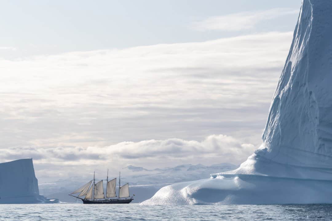 National Geographic Travelさんのインスタグラム写真 - (National Geographic TravelInstagram)「Photo by @daisygilardini / During my latest expedition to Greenland’s Scoresby Sound, we decided to photograph our ship—the 94-year-old, three-masted schooner Rembrandt van Rijn—sailing among icebergs. What looked to be an easy task at first turned out to be a demanding and time-consuming challenge. The Rembrandt is a tall ship, a traditionally rigged sailing vessel, which means all the sails have to be lifted manually without electrical winches. Once the sails are up, the challenge is to board a Zodiac while the ship is moving. Then you hope for a bit of breeze so the sails are nicely rounded and some photogenic icebergs, both in the foreground and background. After an hour or so of bouncing around in the Zodiac, feeling dizzy and seasick, it all came together!  Follow me @daisygilardini for more images and behind-the-scenes stories. #greenland #ship #iceberg #arctic #climatechange」3月1日 8時35分 - natgeotravel