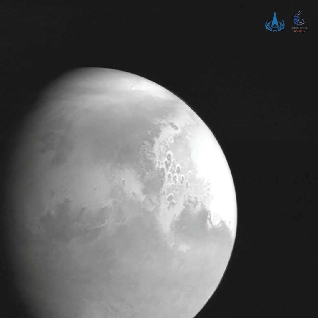 ルモンドのインスタグラム：「La sonde spatiale chinoise Tianwen-1 ("Questions au ciel-1"), qui se dirige vers Mars, a envoyé le 5 février son premier cliché de la planète rouge, a indiqué l'agence spatiale nationale chinoise (CNSA).⁣ Le cliché en noir et blanc a été pris à environ 2,2 millions de kilomètres de Mars et montre Valles Marineris (des canyons à proximité de l'équateur de la planète rouge), Schiaparelli (un vaste cratère) et la plaine Acidalia Planitia.⁣ Tianwen-1, lancé fin juillet depuis la Chine, est attendu aux abords de Mars vers le 10 février. Le robot téléguidé à roues, contenu dans la sonde, devrait être déployé à la surface de la planète en mai. Parmi ses missions: conduire des analyses du sol, de l'atmosphère, prendre des photos, ou encore contribuer à la cartographie de la planète rouge.⁣ Ambitieuse, la Chine espère faire lors de cette première tentative indépendante d'exploration de Mars presque tout ce que les Etats-Unis ont réalisé en plusieurs missions martiennes depuis les années 1960. C'est-à-dire placer une sonde en orbite, poser un atterrisseur, puis en faire sortir un robot téléguidé.⁣ -⁣ La première photo de Mars envoyée par la sonde spatiale chinoise Tianwen-1 le 5 février. Photo : CNSA (@cnsa_china) / Reuters (@reuters)⁣ -⁣ #espace #science #Mars」