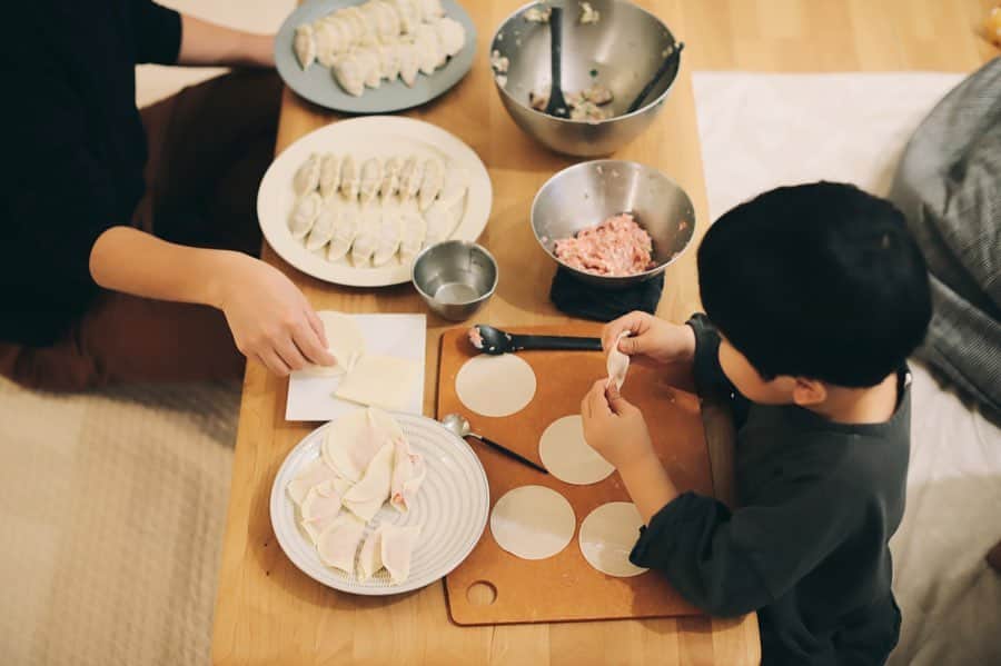 きなこのインスタグラム：「ほぼ月一ペースの我が家の餃子パーティー🥟 週末、家族みんなでせっせと餃子を包み、ホットプレートでじゅじゅっと焼いて食べました。 餃子を包むよー！と私が声をかけると、いつもニコニコでやってくる息子。「UFO餃子」や「てるてるぼうず餃子」「タワーマンション餃子」（！）など、自由な発想でいろんなユニーク餃子を作ってくれます😁  我が家の餃子はキャベツではなく、たっぷりの白菜で作ります。あっさりしていてパクパク何個でも食べられちゃう。大人用には刻んだしそもたっぷり入れるので、香りもたまらない♡余った餡はそぼろにして、ごはんに乗せたり炒飯にアレンジしてます😋  ▶︎我が家の餃子レシピ、ブログで紹介してます👩‍🍳 → @kinako_710  （プロフィールのリンクから見られます☺︎）」