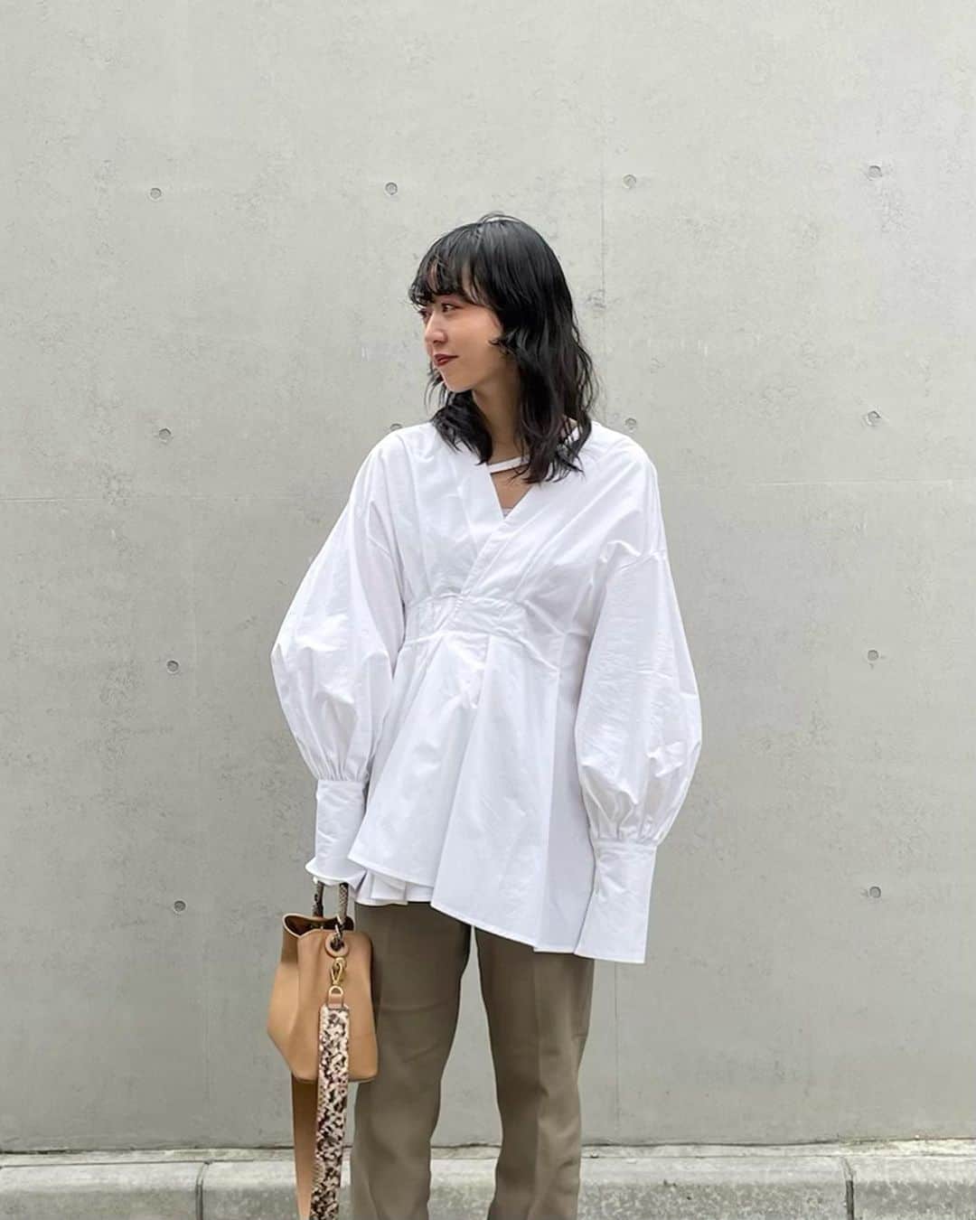 AICOのインスタグラム：「明日から発売のtopsです。 Off shoulder tuck blouse. デコルテの開きと斜めにはしるストラップがオフショルにしてもズレ落ちない機能性も＋しています。 ランダムタックで作られたウエストのシルエットやボリューム袖と長めのカフスから覗く手が女性らしい印象に。 お気に入りで、白と黒の2色をオーダーしました🌹 #clane#21ss」