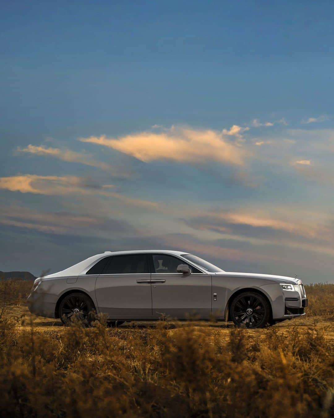 ロールス・ロイスのインスタグラム：「An emblem of perfection, Ghost's precise silhouette stands in stark contrast to nature's coarse edges. Its presence, undeniable.  Discover #RollsRoyceGhost; link in bio.  — NEDC (combined): CO2 emission: 343 g/km; Fuel consumption: 18.8 mpg / 15.0 l/100km. WLTP (combined): CO2 emission: 347-358 g/km; Fuel consumption: 18 – 18.6 mpg / 15.2-15.7 l/100km.」