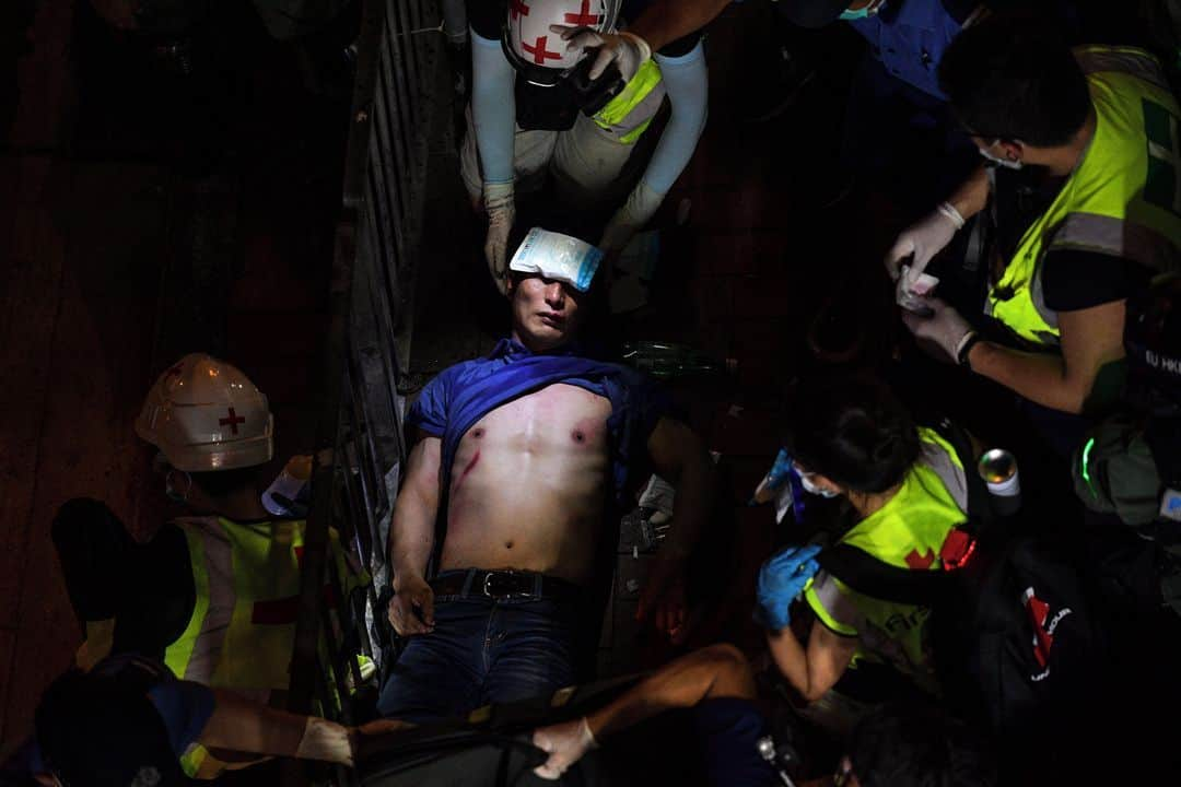 AFP通信さんのインスタグラム写真 - (AFP通信Instagram)「#AFPrepost @worldpressphoto - First-aid carers tend to a man injured during a protest outside the North Point metro station in Hong Kong on 15 September 2019.⁣⁣  ⁣⁣ From ‘Hong Kong Unrest’ by 📷 Nicolas Asfouri, for Agence France-Presse (@afpphoto).⁣⁣  ⁣⁣ Protests began in Hong Kong at the end of March 2019 in response to government proposals to amend existing legislation and allow extradition to mainland China. Anti-government demonstrations gathered momentum over the following weeks as pro-democracy groups united, with students playing a large role in protests and in human-chain rallies. On 12 June, tens of thousands of demonstrators gathered around the Legislative Council building ahead of a debate on the extradition laws, and met with violent opposition from police. Protests continued to escalate, both in frequency and size, as did police countermeasures. The authorities banned the wearing of face masks, and at a demonstration on 1 October, the day marking the 70th anniversary of the declaration of the People’s Republic of China, police fired live ammunition at protesters for the first time. After initially proposing postponements and amendments to legislation, Chief Executive of Hong Kong Carrie Lam eventually announced that she would withdraw the bill. This was done on 23 October, but protesters’ demands had broadened to include implementation of genuine universal suffrage and release of arrested protestors, and unrest continued into 2020.⁣⁣  ⁣⁣ Nicolas Asfouri is a Danish national, born in Beirut, Lebanon, who has worked for Agence France-Presse (AFP) for 19 years, covering a wide range of news events and conflicts. Since 2016, he is the senior photographer in AFP’s Beijing bureau in China. His project ‘Hong Kong Unrest’ was awarded 1st prize, stories in the General News category of the 2020 Photo Contest. Follow the link in the bio to learn more about the project and the photographer.」2月9日 12時41分 - afpphoto