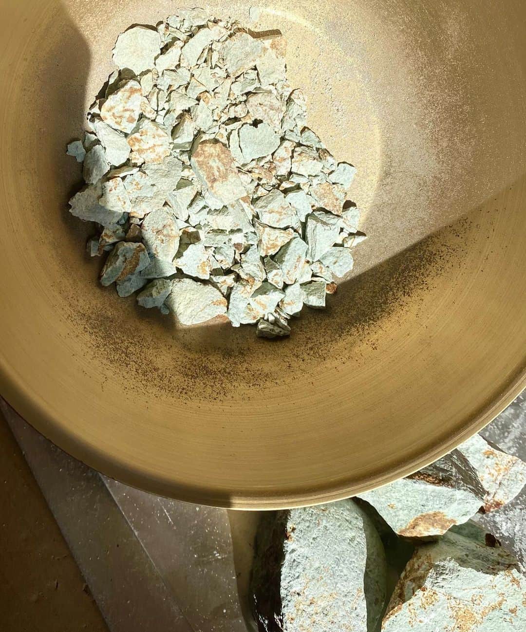 SUGAYA MASAKI / SHIMAさんのインスタグラム写真 - (SUGAYA MASAKI / SHIMAInstagram)「Material research ： Riverside minerals  _ 征く先々で採集した鉱物。 それを粉砕し、粉状にします。それから膠を使って混ぜ合わせ、岩絵具を作成。支持体（紙や布）との整合性、親和性を探りながら、自然との深い関わりから何が生まれるのか。ー　 天然の鉱物ゆえに予期しない範囲へと色や質感は向かい、自分と自然との間に存在する“何か“を可視化します。  時間を見つけるとすぐに東京を飛び出し、自然界へ赴くことが日課である私は日本の様々な土地を旅をしてきた。景色を眺め、一息つくのが主な目的であり、大概のことはそれでリフレッシュされる。自然の恩恵をたくさんもらってきた中で、人間（自分）と自然との関係性や緊張感、そこに在る空気のようなものをメッセージとして生み出したいと考えました。 採集した3種類の鉱物はそれぞれ標高、地形の違いを意識し、標高が比較的高い火山跡の土地では赤茶のもの、丘の続く土地から黒ずんだ青緑、下流の河原に流れ着いていた薄緑の鉱物を対象に。異なる地形や標高、存在していた環境によって密度の違いがあり、硬さや色の出方は様々になります。これら鉱物から色味を抽出し、現象に近しい状態で支持体へアプローチ。その'何か'について発見することを目的として制作をしています。」2月10日 1時02分 - masaki_sugaya