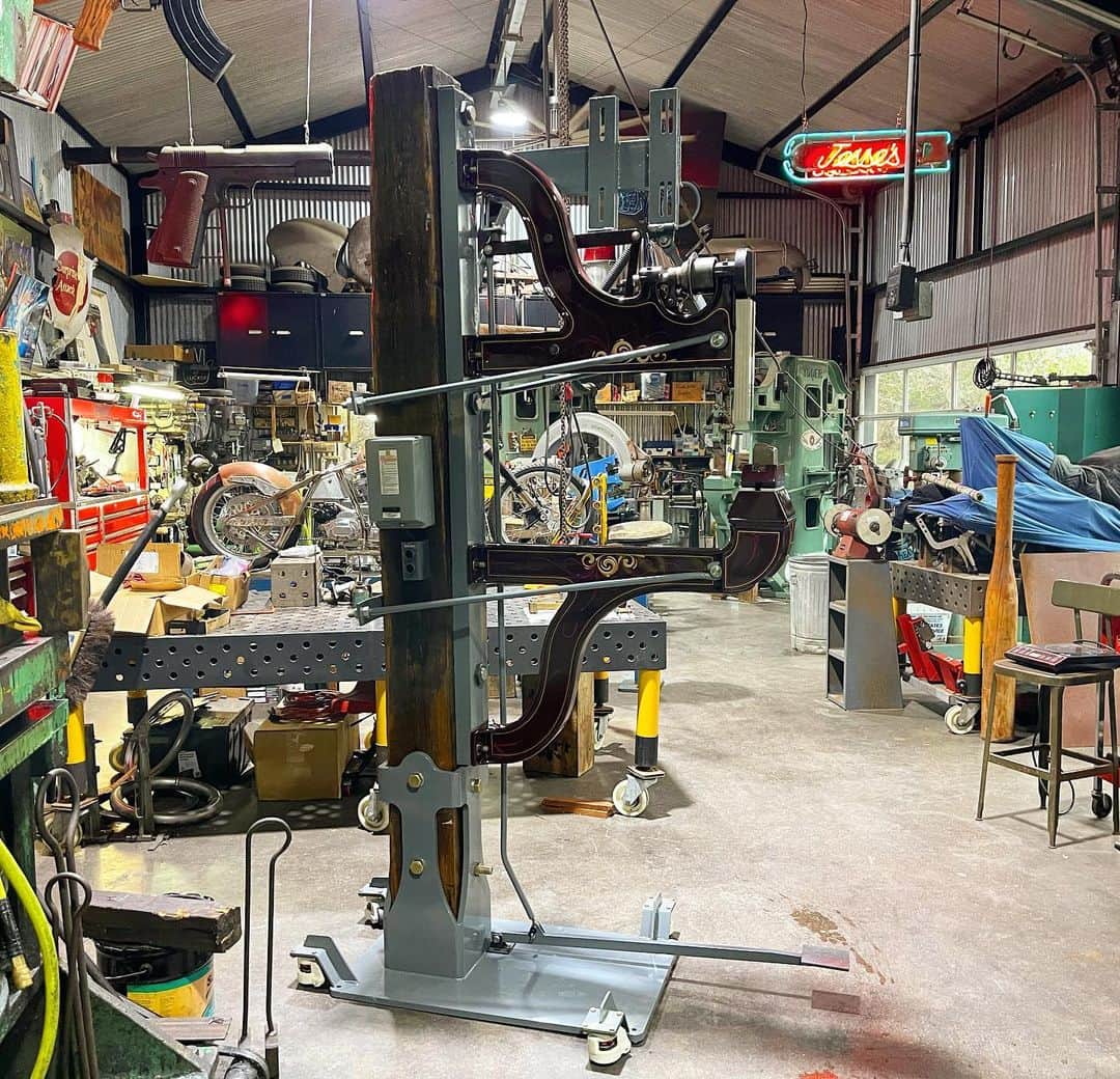 ウエストコーストチョッパーズのインスタグラム：「Finally after getting side tracked for a year filming Monster Garage. I’m getting my favorite Pettingell power hammer back together.  I put it on a 100+ year old beam out of a sugar mill. Alex our wood dude put a awesome resin finish on it. I forged support rods/mounting plates and redid all the pedal and all New linkage.   Joe at the shop made the heavy steel base with stabilizing casters.  Darren did a classy period style paint on the arms. He still needs to finish the motor, it was out getting re-wound.  Also big thank you to @pettingellmachineco for re-lining the OG leather clutch🙏🏻  All that’s left beside motor is re-stringing the banding on the upper anvil and leaf springs. And electrical.  Piece of Cake!  #jessejames」