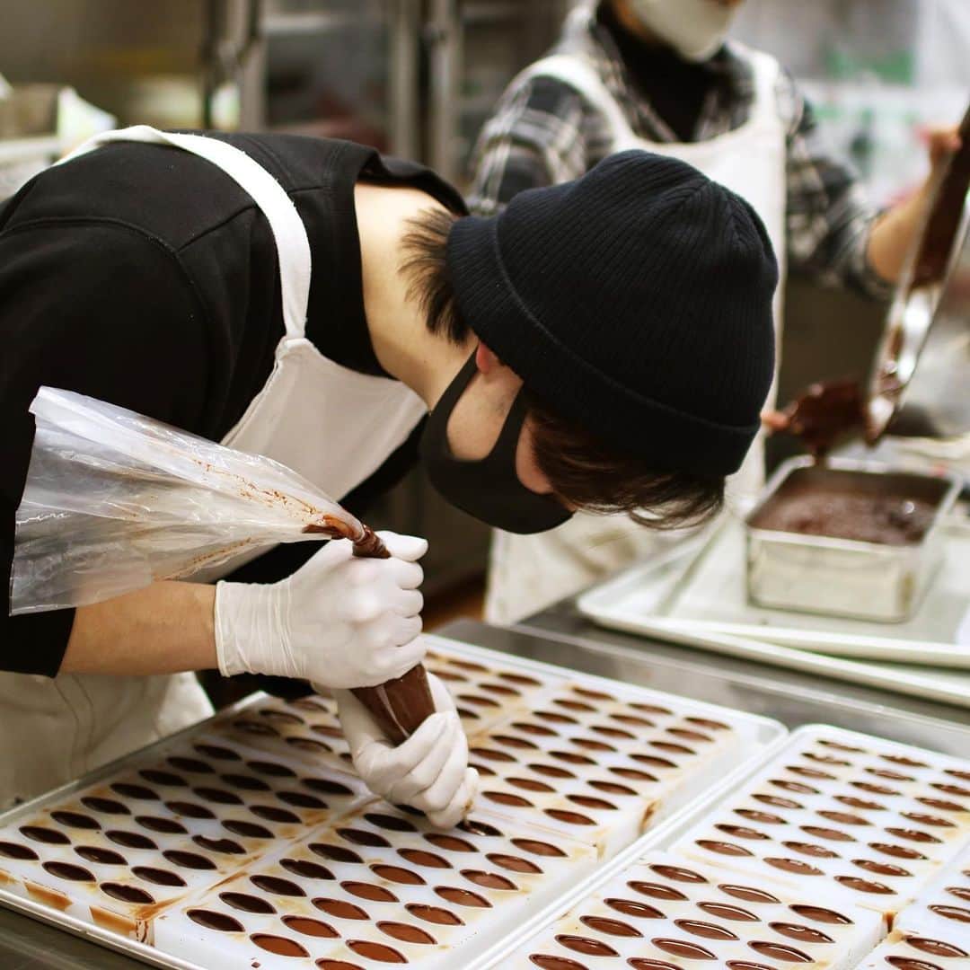 ダンデライオン・チョコレート・ジャパンさんのインスタグラム写真 - (ダンデライオン・チョコレート・ジャパンInstagram)「チョコレート作りを仕事にする人を「チョコレートメーカー」や「ショコラティエ」と言い表すことがあります。どちらもチョコレートに携わるのには変わりありませんが、扱うものや作るものには少し違いがあります。  ■チョコレートメーカーとショコラティエ 原材料となるカカオ豆を仕入れ、チョコレートを製造するのが「チョコレートメーカー」（Chocolate Maker = チョコレートを作る人）です。 ちなみに「メーカー」という言葉は、日本では「何かを作っている会社（製造会社）」を指すこともあるため、混同しやすいかと思います。 ダンデライオン・チョコレートを始め、多くのBean to Bar メーカーは、カカオ豆からチョコレートを作っているので、チョコレートメーカーということになります。  これに対して「ショコラティエ」は、チョコレートからボンボンショコラやオランジェットやタブレットなどのチョコレート菓子を作る、チョコレート専門の菓子職人を指します。 「パティシエ」は洋菓子全般を扱いますが、ショコラティエはチョコレート中心。チョコレートも同じ洋菓子に括られますが、専門性が高くまた奥が深いため「ショコラティエ」というこべつの職業があります。日本ではパティシエを経験し、ショコラティエになる職人も多いそうです。  ■日本のチョコレート業界 日本のチョコレート業界は、大手チョコレート企業、ショコラティエ、Bean to Bar チョコレートメーカーと、大きく3つに分類されます。  大手のチョコレート企業は、森永製菓（@morinaga.choco）や明治（@okashihappy_jack）、ロッテ（@ghana_recipe）などが馴染み深いかと思います。 ショコラティエですと、日本ではミュゼ・ドゥ・ショコラ テオブロマ（@gelateria_theobroma）やル ショコラ ドゥ アッシュ（@lechocolatdeh_ginza）、ショコラティエパレドール（@palet_dor）などをご存知でしょうか。 Bean to Bar チョコレートメーカーは、わたしたちダンデライオン・チョコレートの他にも、ミニマル（@minimal_beantobarchocolate）やグリーンビーントゥバーチョコレート（@greenbeantobar_chocolate）、カカオ研究所（@cacaoken）などがあります。  場合によっては、「大手菓子メーカー」が「Bean to Bar チョコレートメーカー」であったり、「ショコラティエ」が「チョコレートメーカー」でもあったりします。それぞれの分野で重なり合う部分があることも、この業界の面白さだと思います。  例えば、大手菓子メーカーの中でショコラティエの分野にも積極的に取り組んでいるブランドとして、「メリーチョコレートカムパニー」が手がけるTokyo Chocolate （@marychocolate.jp）があります。チョコレートの本場フランスで開催される「サロン・ドゥ・ショコラ」で、日本の素材を使ったチョコレートで挑戦し続けたストーリーは、業界でも大変有名です。  わたしたちのようなBean to Bar チョコレートメーカーから見ると、大手のチョコレート企業やショコラティエが手がける、Bean to Bar チョコレートというものも、とても興味深く刺激になります。  日本で、Bean to Bar チョコレートという言葉が大きく普及したのには、「明治」が手がける明治 ザ・チョコレート（@meiji_the_choco）の発売が大きかったと思います。大手企業だからこそ出来る、Bean to Bar チョコレートの工業化によって、一気に「Bean to Bar」という言葉の認知度があがりました。  そして、ショコラティエが作る Bean to Bar チョコレートにもまた格別な味わいがあります。1999年にオープンした「ミュゼ ドゥ ショコラ テオブロマ」では、オーナーの土屋シェフが自ら産地に赴き、厳選したカカオ豆で Bean to Bar チョコレートを作っています。 また、三枝シェフは、2019年に「ショコラティエ パレ ド オール ブラン」という世界初のホワイトチョコレートのBean to Bar チョコレート ブランドを立ち上げました。  それぞれ企業規模やアプローチは異なるものの、チョコレートに対する想いや「美味しいものを届けたい」という気持ちは共通しています。また、お互いを「競合」とせず「同じチョコレート業界を盛り上げる仲間」と捉えて接することが出来るのも、わたしたちがチョコレート業界を好きな理由でもあります。  一つの分野にとらわれず、様々なチョコレートをお楽しみいただけますと嬉しいです。」2月12日 13時09分 - dandelion_chocolate_japan