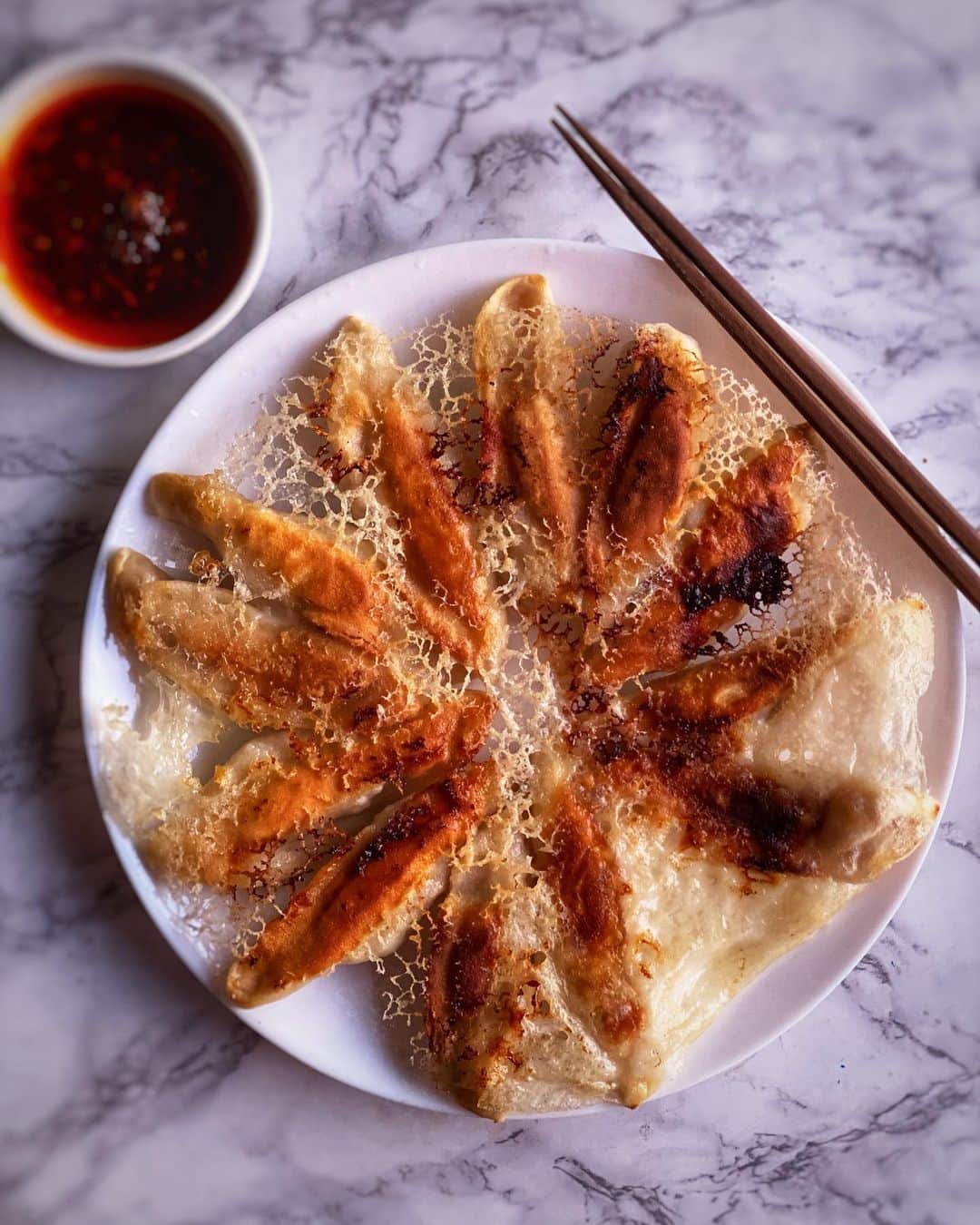 Antonietteのインスタグラム：「There’s dumpling 🥟 you should know about....after making the crispy dumpling skirt I love flipping the pan onto a plate and unraveling the dumplings in all its’ lace like glory.  Love the crispy texture! Can’t do Lunar New Year without dumplings which symbolize luck and fortune! 🧧」