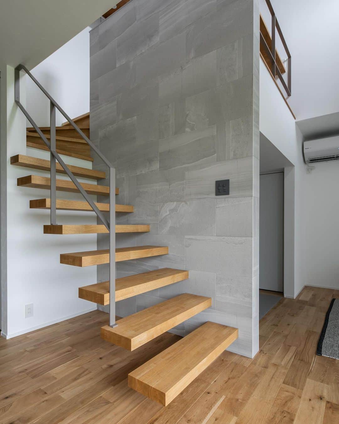 ルポハウス一級建築士事務所さんのインスタグラム写真 - (ルポハウス一級建築士事務所Instagram)「・ ・ ・ 美しいオブジェのような片持ち階段｡ ・ ストーンのクールな壁面に木目の温かさがプラスされ、吹き抜け空間のアクセントに｡ ・ ・ ・ 𓐌𓐌𓐌𓐌𓐌𓐌𓐌𓐌𓐌𓐌𓐌𓐌𓐌𓐌𓐌𓐌𓐌𓐌  ルポハウスの施工事例はこちらまで☞ @reposhouse  𓐌𓐌𓐌𓐌𓐌𓐌𓐌𓐌𓐌𓐌𓐌𓐌𓐌𓐌𓐌𓐌𓐌𓐌 #ルポハウス は#ちょっとかっこいい家 を"友人のために" という思いでつくっています。 一生に一度の#マイホーム。 「あなたにしかできない」×「ルポハウスだからできる」で、 私たちだけの#家づくり を思いっきり楽しんでみませんか？！ ・ ・ ・ #注文住宅 #新築一戸建て #デザイナーズ住宅  #一級建築士事務所 #設計事務所 #滋賀県の設計事務所 #myhome #instahouse #design #instahome #myhouseidea #スキップフロア #無垢床 #ナラ床 #チーク天井 #ユーティリティールーム #エコカラット #エコカラットプラス #ストーングレース #ダイケン健やかおもて #銀鼠色  #吹き抜けリビング #リビングインテリア #方持ち階段」2月14日 20時59分 - reposhouse