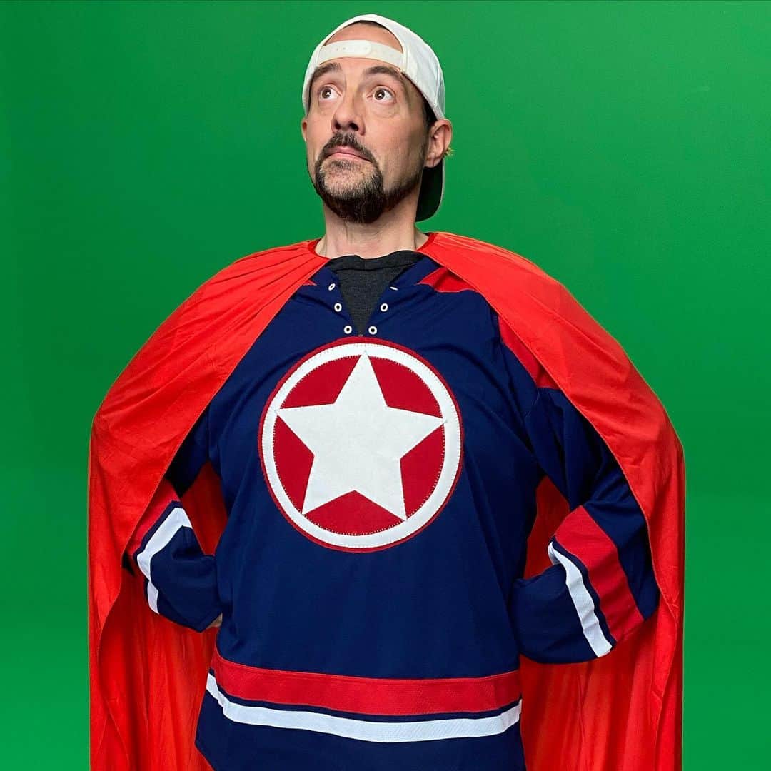 ケヴィン・スミスのインスタグラム：「It’s SUPER MEGA AWESOME ULTRA GUY! A few years back, I was a guest on Ask The @storybots - an excellent kids’ show on @netflix! Of all the things I’ve made or been in, not a week goes by when I don’t hear from some parent who Tweets or writes “I was watching this show with my kid and suddenly, you were flying around in it!” So on Friday, I was lucky enough to return to the role I originated when @espiridellis brought me back to do more episodes of Storybots, including the desolation of SMAUG (Super Mega Ultra Awesome Guy)! Many thanks to the always awesome @theartistred, who made me up to look heroic and fixed all my cape fears! And since we were both Covid tested in advance of the shoot, we played it risky for 30 seconds to snap selfies sans masks in the dressing room before hitting the green screen stage! It’ll be a minute before this episode is done, so I’ll let you know when it’s gonna air! #KevinSmith #storybots #theartistred #supermegaawesomeultraguy #cape #superhero」