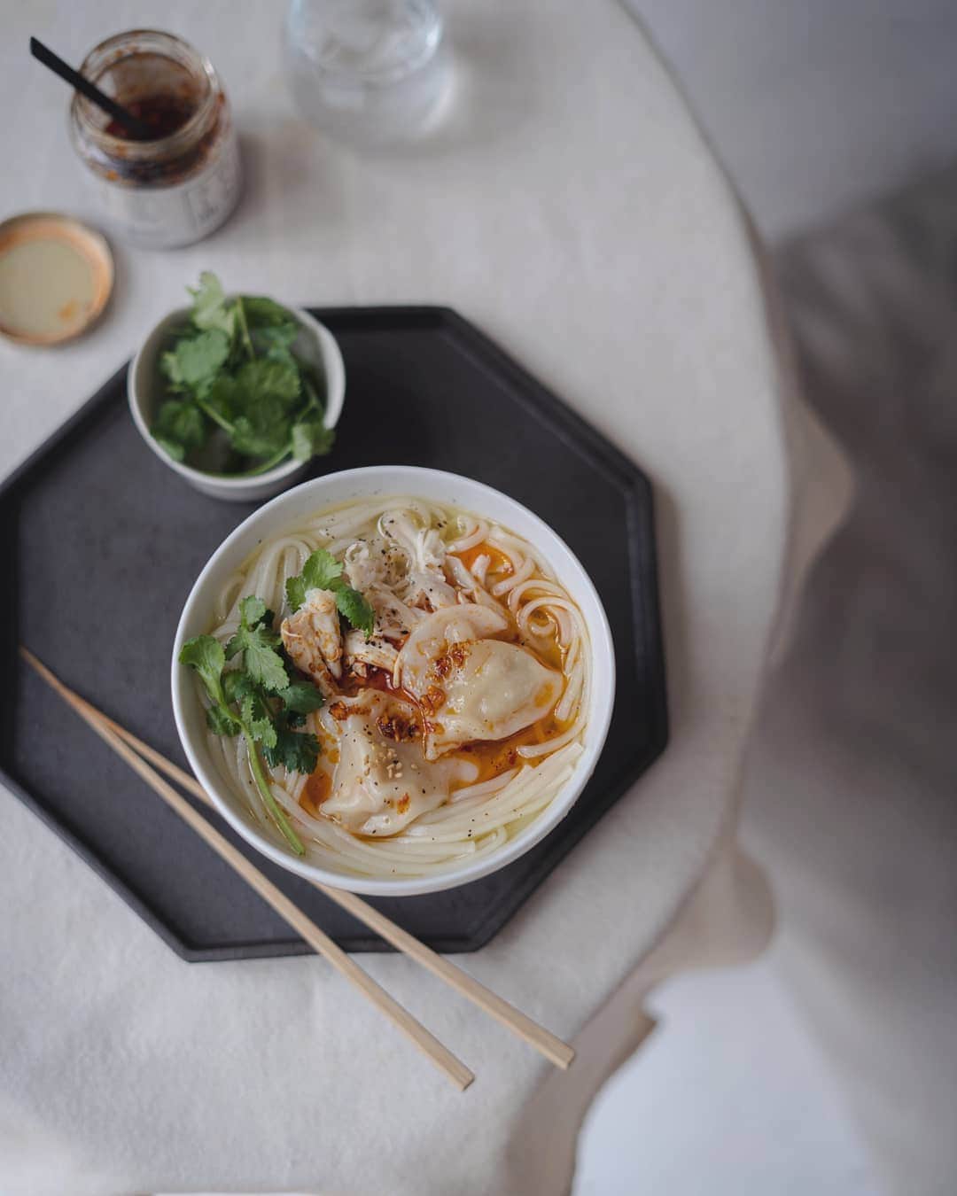 のインスタグラム：「『フォーみたいなもの。』  昨日茹で鶏のスープ方は ナンプラーで味付けして フォーみたいなスープに。  冷凍水餃子もおまけして 具沢山なラー油もトッピング。  パクチーがあう。」