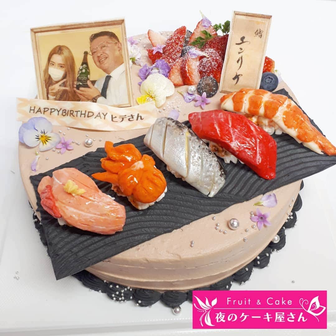 夜のケーキ屋さん♥Juli　(エディブルフラワー協会) のインスタグラム：「#鮨エンリケ 🍣×🎂 お寿司ケーキ🎶 : : エンリケさんのお寿司屋さんにお届け🎂 男性でも喜んでくれそうなケーキで、鮨エンリケでのお祝いだからお寿司ケーキをお作りしました🍣 お皿もお寿司も写真も全部食べられます🍴 ネタは○○○、シャリは○○○👌 : エンリケさんがストーリーで食レポしてくれて「普通に美味しいっ」って笑ってくれました😍💓 お祝いのケーキだから、笑って盛り上がってくれたら、とっても嬉しいです💛 : @eri.ogawa1102 @buta_san1102  : #鮨エンリケ 🍣 ☝このハッシュタグのお寿司たちを見ながら、お寿司ケーキ作りました😍 : : #夜のケーキ屋さん #写真ケーキ #オーダーケーキ #銀座」