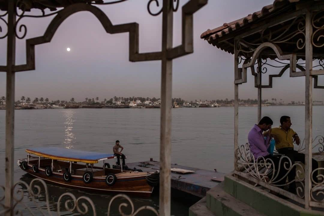 National Geographic Travelさんのインスタグラム写真 - (National Geographic TravelInstagram)「Photo by Brendan Hoffman @hoffmanbrendan / People sit along the banks of the Shatt al Arab as the moon rises over Basra, Iraq. This is from a visit in 2010—a moment of calm and beauty in a place rarely associated with those words. I find it's impossible to reduce a place to any single descriptor. Our world is complex, containing multiple truths depending on one's perspective. What good does it do to oversimplify and miss the nuance when nuance is where the beauty lies?  Follow me @hoffmanbrendan for more human stories from around the world. #basra #iraq #shattalarab」2月19日 4時37分 - natgeotravel