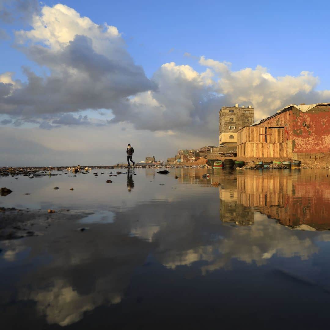 のインスタグラム：「AFP Photo 📷 @mahmud_hams - A Palestinian man walks at the beach in the al-Shati refugee camp in Gaza City following heavy rain fall on February 18, 2021.」