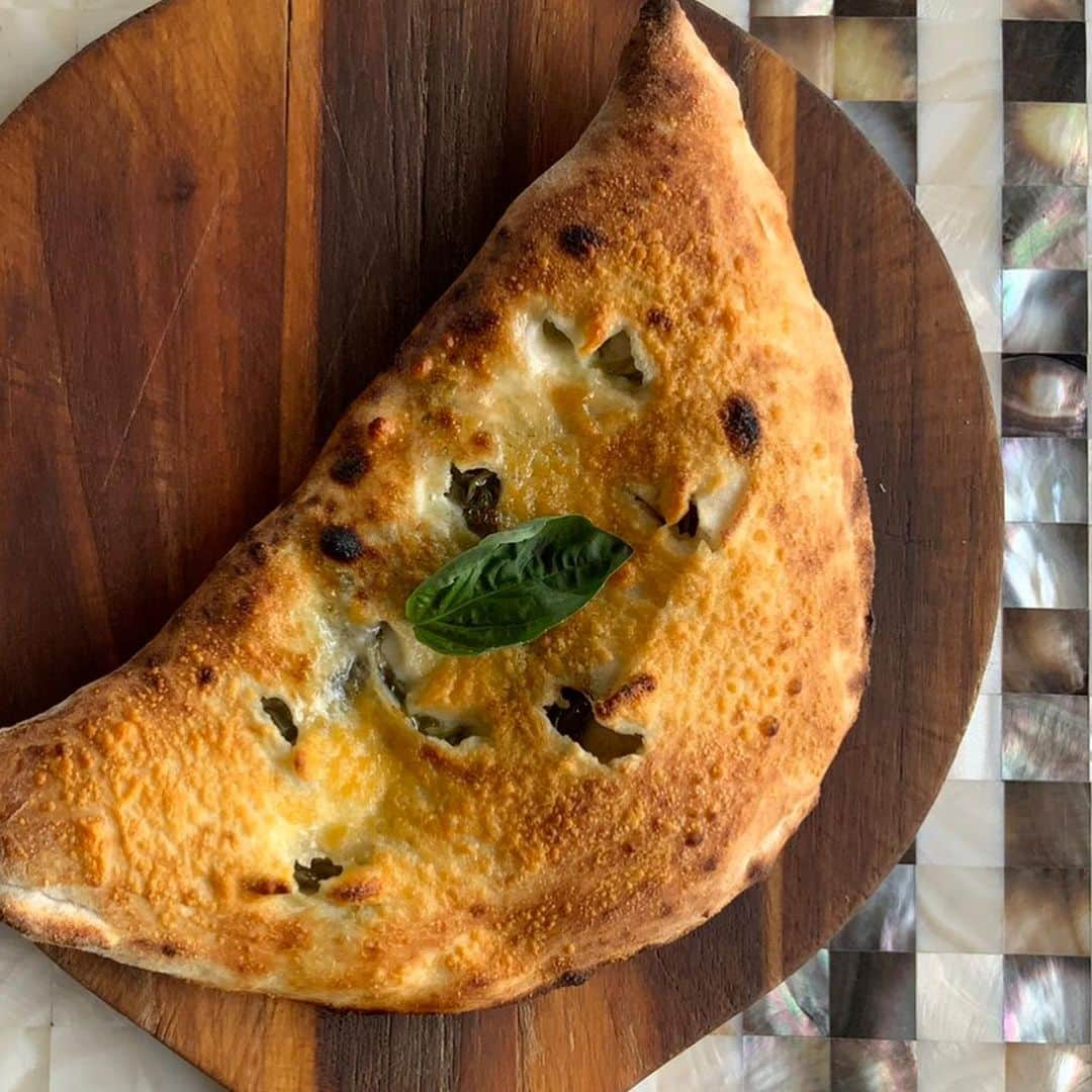 ポジリポのインスタグラム：「「Calzone con Erbe」 カルツォーネとは包み焼きのピッツア  中には青菜のコンフィ、アンチョビ、モッツァレラチーズ  イタリアビールと一緒に  お待ちしております  ≪ALL NATURAL≫ NO MSG and ZERO TRANS FAT,ORGANIC SUGAR,NATURAL SALT  [Access]﻿ 沖縄県豊見城市字瀬長174-5 ﻿[Hours]﻿ 11:30-20:00 [Tel]﻿ 098-851-1101 ﻿ [Web]﻿ http://www.posillipo-cucina.jp/﻿ ﻿ ▼ご予約はプロフィールページ @posillipo_okinawa のリンクより ﻿ ﻿@huge_restaurant #huge_restaurant ﻿ #posillipo #okinawa #okinawatrip #okinawaitalian #okinawalunch #senagajima  #tomigusuku #foodlover #foodie #goto #gotoeat #ポジリポ #ポジリポ沖縄 #沖縄ランチ #沖縄イタリアン #沖縄ピッツァ #沖縄パスタ #沖縄ワイン #沖縄グルメ #沖縄食材 #沖縄夕日 #那覇空港 #沖縄旅行 #豊見城 #瀬長島 #ウミカジテラス #gotoeat」