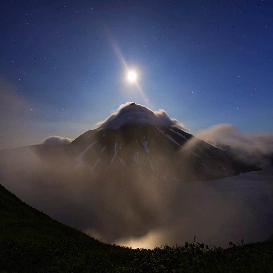 クリス・バーカードのインスタグラム：「Moonrise over the Onekotan crater. A central volcano in the Kuril Island chain and home to the ancient Ainu people. Indigenous to Japan & the original inhabitants of this string of remote islands stretching from Hokkaido to Kamchatka, Russia. It’s been said that you can feel a deeper magnetic vibration, or rather, a pull towards these islands because of the raw volcanic activity. Having been there I can’t say for sure whether that is true or not. But no doubt there is an attraction that at times defies logic.」