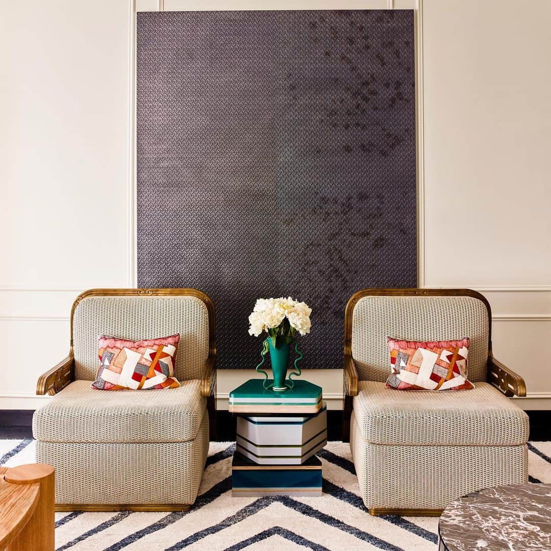 ケリーウェアスラーのインスタグラム：「TWINNING. A pair of 1960s Maison Jansen armchairs, a graphite painting by Adam McEwen, and a graphic chevron rug create perfect ground for the gemstone side table by @hellajongerius. XK」