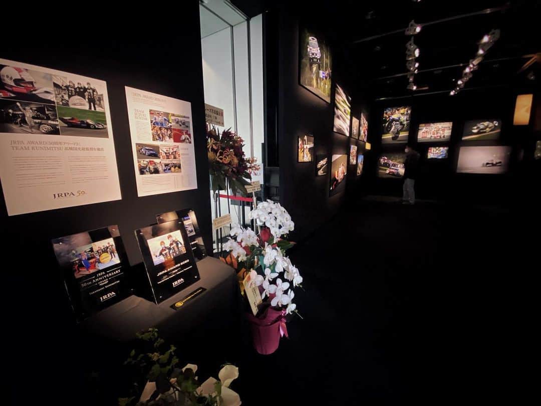 水村リアのインスタグラム：「JRPA 50周年写真展📷﻿ ﻿ ﻿ 毎年楽しみにしている﻿ JRPAさんの写真展👏﻿ 今年は50周年の記念すべき年に﻿ 品川のキャノンギャラリーで開催されます🥳﻿ ﻿ ここのギャラリーとても好き😇﻿ ﻿ ﻿ 生まれる前のレースから﻿ 思い入れ沢山の2020年まで。﻿ わたしがモータースポーツに関わって﻿ 知っているレースの年はまだ全然少ないけど﻿ どれもめちゃくちゃかっこよかった🥲﻿ ﻿ ネガからデジタルに移り変わる﻿ 歴史とテクノロジーの流れが写真で見えるよ﻿ と会長が写真展の楽しみ方も教えてくれました😌﻿ ﻿ ﻿ 50周年アワードに﻿ TEAM KUNIMITSU 高橋国光総監督を﻿ 2020年のアワードに﻿ 山本選手と牧野選手が選ばれました👏﻿ 🦈🦈🦈﻿ ﻿ ﻿ お近くの方は是非🙂﻿ 日曜日はお休みなのご注意を📷﻿ ﻿ ﻿ ・﻿ ・﻿ ・﻿ #JRPA﻿ #JRPA写真展﻿ #JRPA50周年写真展﻿ #キャノンギャラリー品川﻿ #モータースポーツ﻿ #日本レース写真家協会﻿」