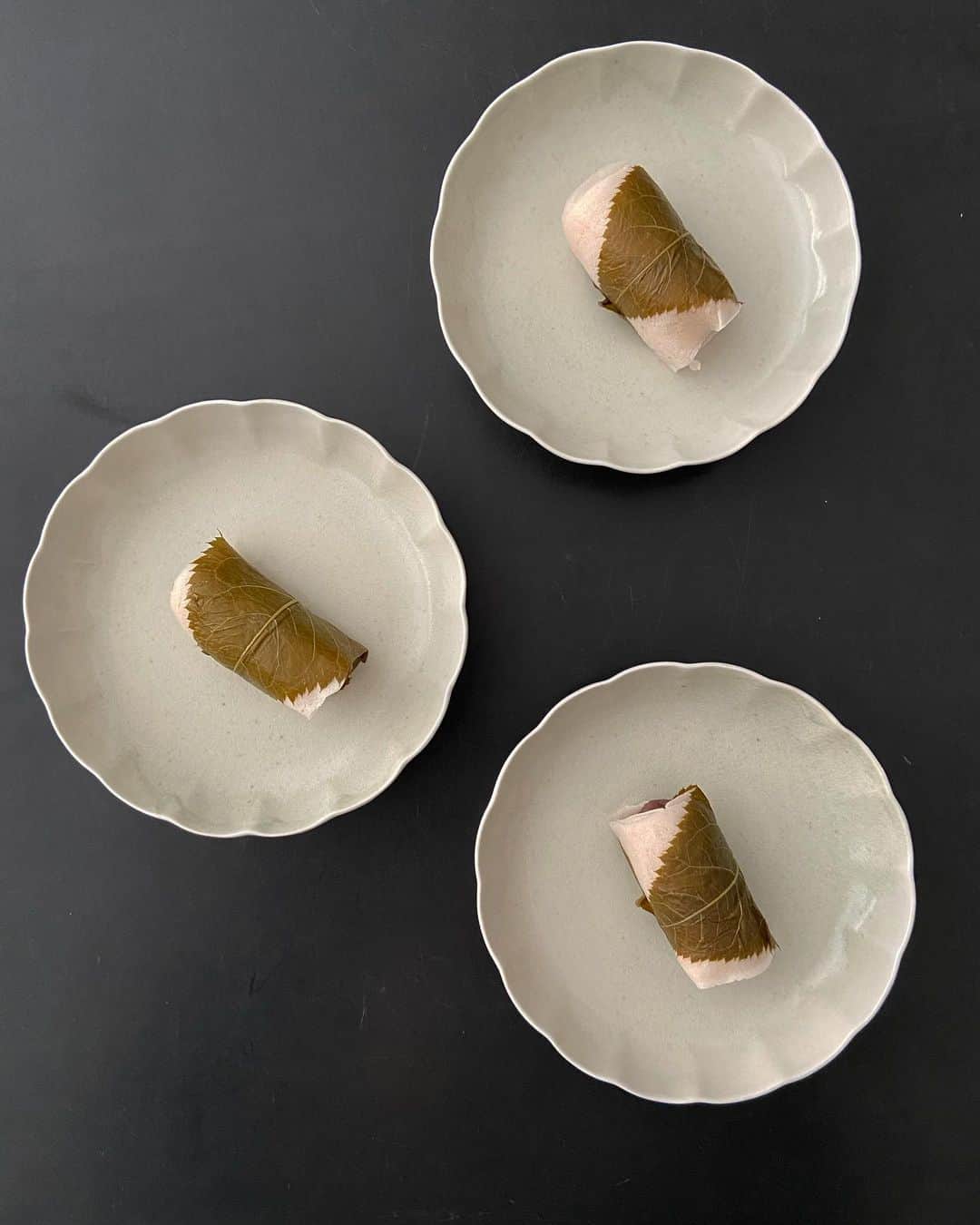 渡辺有子のインスタグラム：「桜餅を見かけたら買わずにはいられません。今日の桜餅はフードフォーソート上原店近くの「菓子司 岬屋」さん。私の手土産リスト上位に入っているお店です。 角田淳さんの花皿にのせてみました。この花皿は控えめな佇まいですがお料理やお菓子をスッと受け止めてくれ、重宝するお皿です。  春はそこまでやってきていますね！🌸  @foodforthought_shop  @matsubara.ryoma_tsunoda.jun」