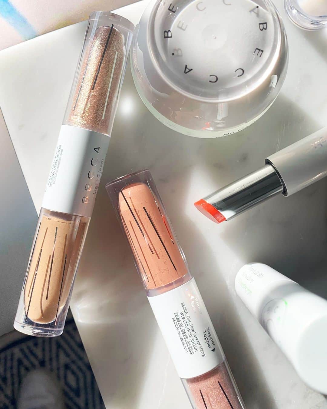 BECCAのインスタグラム：「This weekend, skip the heavy makeup. Skip the brushes. Grab these BECCA essentials to perfect skin and add color and light to your eyes using nothing but your fingers.   🌫 Zero No Pigment Virtual Foundation smooths, blurs, and perfects the appearance of skin. 🌫 Zero No Pigment Glass Highlighter For Face + Lip gives skin a glass-like shine without the sticky feel. 💫 Light Gleam Primer + Topper Liquid Eyeshadow is a dual-ended eyeshadow for multiple looks. 💧Hydra-Light Plumping Lip Balm plumps and smooths lips with a layer of light-reflecting color.」