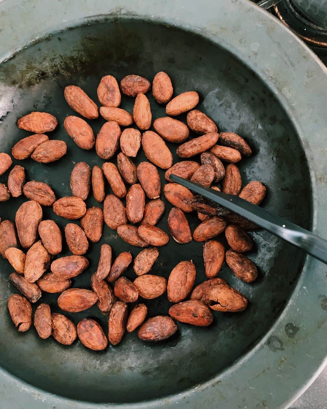 鎌田安里紗さんのインスタグラム写真 - (鎌田安里紗Instagram)「最近の #littlelifelab  カカオ豆を焙煎して、皮を剥いて、砕いてすりつぶして、チョコをつくった。たぶん少し煎りすぎたのと、なめらかにしきれなかったので、香ばしいじゃりじゃりしたおやつが完成🍫それはそれでおいしいんですけど、やっぱり市販品はすごい🍫 生カカオ豆はダリケーさんで買いました。なめらかなチョコにすべく、ひたすらすりつぶしているあいだに、インドネシアに留学し、カカオ農家の調査を行っていたラボメンバーが農園の様子から、カカオの種類や発酵について教えてくれた。 この複雑な工程を工業化して、100円の板チョコを作れるようにした人間の熱意👏🏻となりつつ、その安さゆえにこれだけの工程を経ているおもしろさや美味しさを、味わってたのしむ機会をスルーしてたらもったいないので、自分で何でも作れるようになるためでなく、受け取り力をあげるためにつくる経験が必要だな〜と思ったりしました🦥 #服のたね もたぶんそのための企画。受け取り力向上。そして着ることのよろこびが増える、かもしれない🦥」2月21日 13時35分 - arisa_kamada