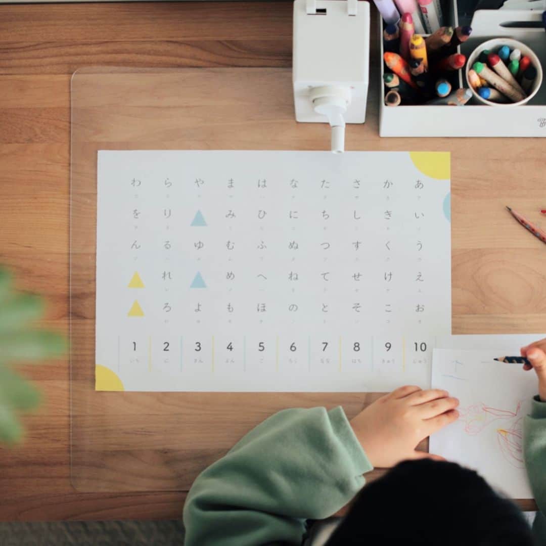 きなこのインスタグラム：「息子のおえかきスペース🖍 5歳になると文字を書ける子も多いのかな。息子ができるのはまだ読みだけ。文字を書くより、絵を描いたり物作りするのが大好きだし得意。最近はひらがなの練習ドリルのようなものは「こんな簡単なものはしないよ」と強がって絶対にやらない😂 （でもこの前💩ドリルだけはめちゃくちゃ楽しそうにやってた。恐るべし💩パワー！）  入学まであと一年、息子のペースで楽しく文字と付き合っていって欲しいな。あいうえお表を見ながらだとゆっくり書けるので、手元で見やすいように透明のデスクマットの下にも表を入れてみました。手紙を書いたり、おえかきした絵にタイトルを書いたり、、生活の中で自然と文字を書く機会が作れるように。透明デスクマット、お気に入りの作品を挟めたり、机も汚れずとても便利👀♡  ひらがなもカタカナも数字も一枚にまとまったシンプルな表がなかなかなくて、自分で作ってみました。ブログでダウンロードできるようにしているのでよかったらどうぞ☺︎  ▶︎使っているデスクマットやひらがな練習に役立ってきたアイテムをブログで紹介してます☺︎ → @kinako_710」