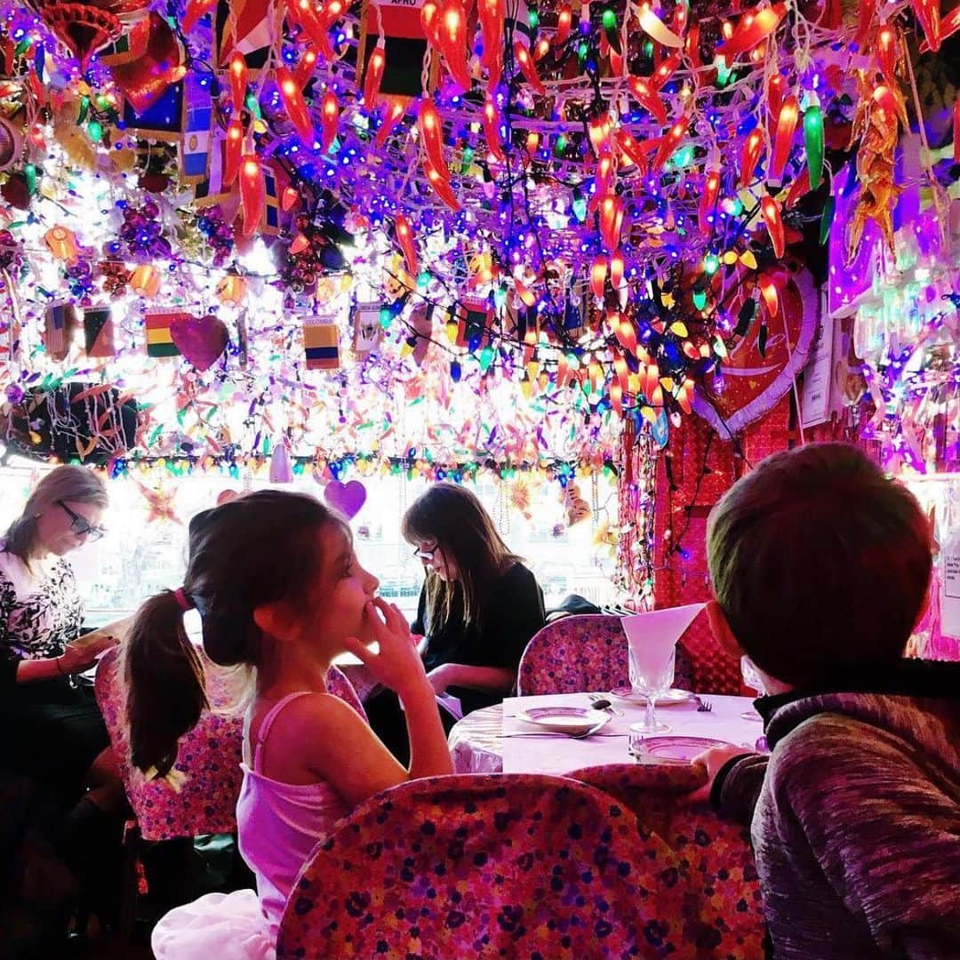Ilana Wilesのインスタグラム：「One of my fave places in NYC is a little Indian restaurant on 1st Ave called Milon. I’ve been going there for 20 years, ever since my mom introduced me to it. My mom fell in love with Indian food when she worked in the city before she got married, because they had cheap lunch specials and she was strapped for cash. After she met my dad, they moved to Long Island, had kids and she stopped working, so she never ate Indian anymore. Going to Milon with my mom and her introducing me to all these new flavors was like a window into her life before I was born. Her favorite food is Indian food?? I had no idea! Milon became a go-to for my friends when we were in our 20s. It was inexpensive, delicious and great for birthdays. They flash the lights, blast a techno song and everyone claps as they bring out a scoop of ice cream. Milon is next to another Indian place called Panna. They serve the same menu, both have a billion Christmas lights year round, and even share a staircase to the entrance, where there are always two men vying to get you to go to one restaurant over the other. Regulars have a preference and never deviate. My friends are Milon people. We swear that it is infinitely better than Panna. When we tell people to go, we say, “MAKE SURE YOU GO TO THE ONE ON THE LEFT.” If we meet a Panna person, we get into a heated debate. The rumor (unconfirmed) is they’re owned by two brothers who got into a fight. I’ve also heard they share a kitchen and the competition is a ruse. I remember the first time I took Mazzy. It was like walking into a tiny jewel box of lights. We pretended it was her birthday and she fell in love. This fall, I tried to order takeout and found out they closed down. I walked down there and saw Panna closed too. Those two windows full of lights, both dark. There have been a lot of places that closed due to COVID, but this hit me the hardest. The other day, I read that Panna is reopening and expanding into the Milon space. I can’t tell you how happy this makes me. I guess I’m a Panna person now. I hope they keep both signs and still have guys trying to urge you into either entrance. Maybe the brothers are back there in the kitchen laughing.」