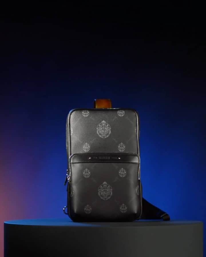 ベルルッティのインスタグラム：「- THE #BERLUTI SIGNATURE CANVAS -  Introducing the “Discovery” crossbody bag in SIGNATURE Canvas.   Designed by @kris_van_assche, SIGNATURE is inspired from Berluti’s archives, blending the Maison’s logo and the undulating strokes of the iconic Scritto motif, and stamped over a black background with strokes of slate and lead grey reminiscent of the Parisian skyline. Made in a textured coated fabric that resists everyday use, SIGNATURE is completed with Berluti’s trademark finishings, including metallic bootmaker studs and Venezia leather details.   Now available In-Store and on the E-Shop.」
